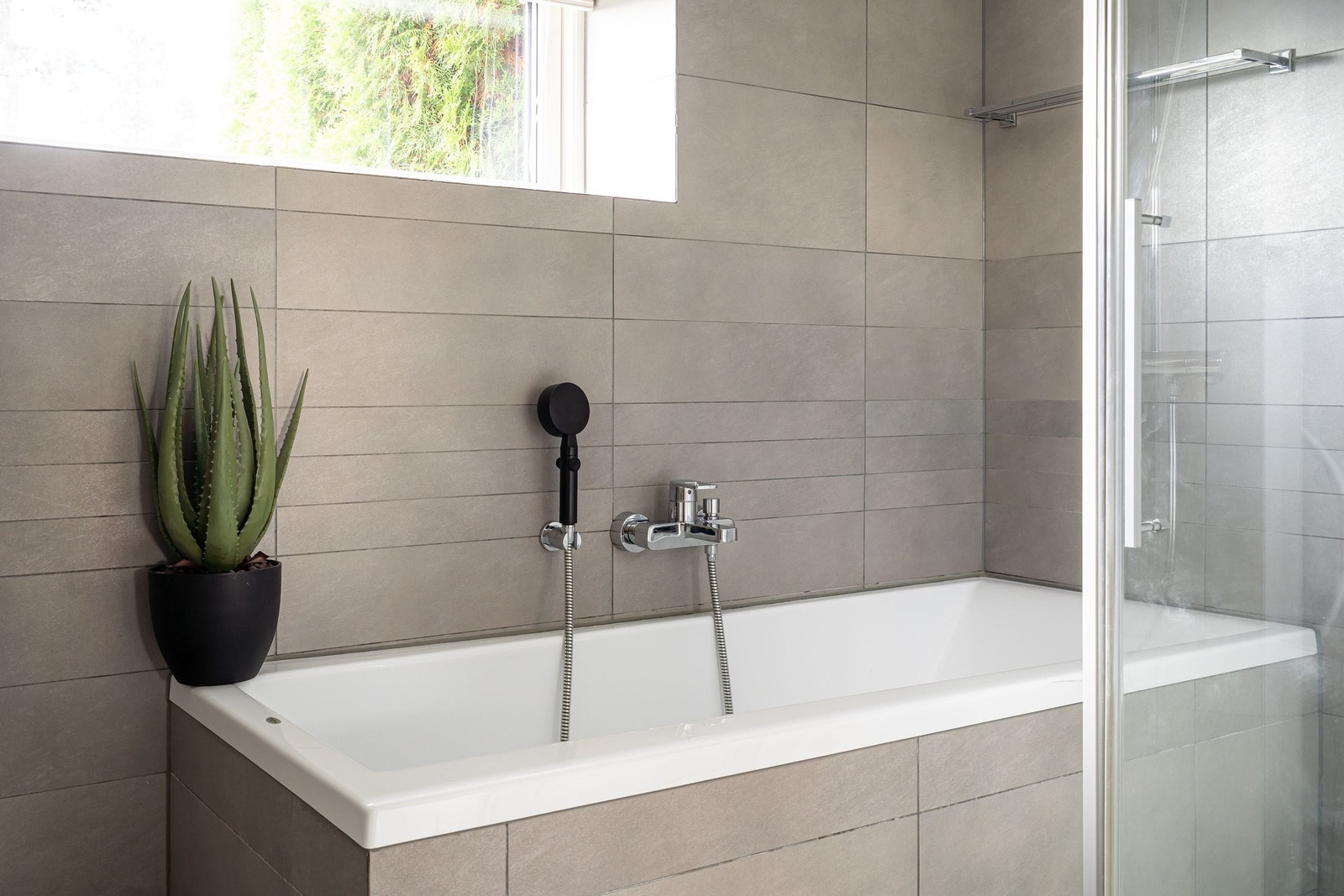 Badet har en dusjkabinett og en badekar. Badekaret er fliset inn i samme fine fliser som badet forøvrig, og er et fint tilskudd til badet for store og små.. Galleribilde