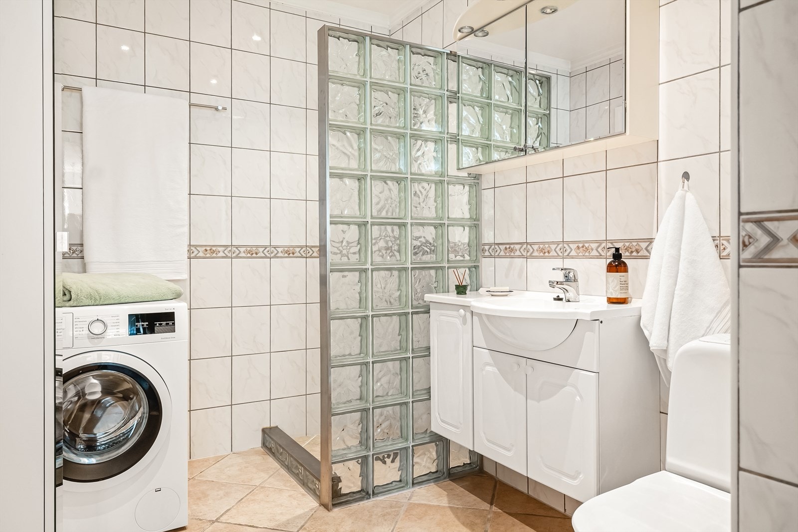 Bad er 5,1 m², helfliset. Varmekabler i gulv og downlights i himlig. Galleribilde