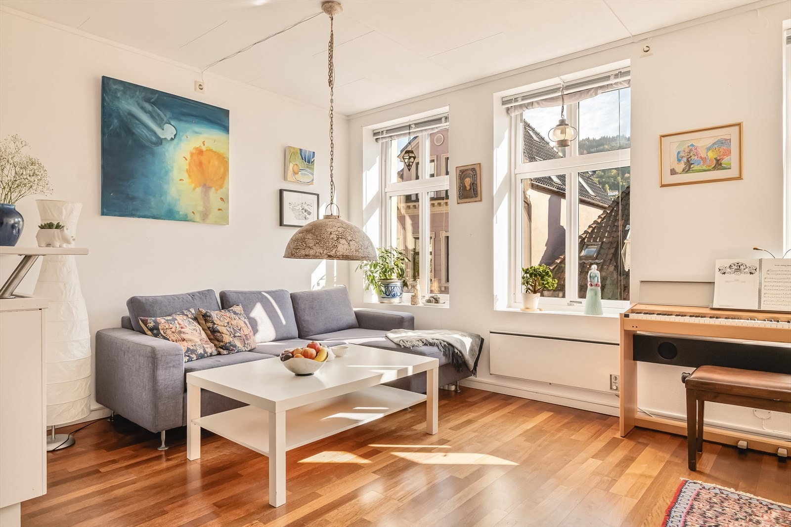 Det er parkett på gulv, malte flater med strie på vegg, og takplater. Galleribilde