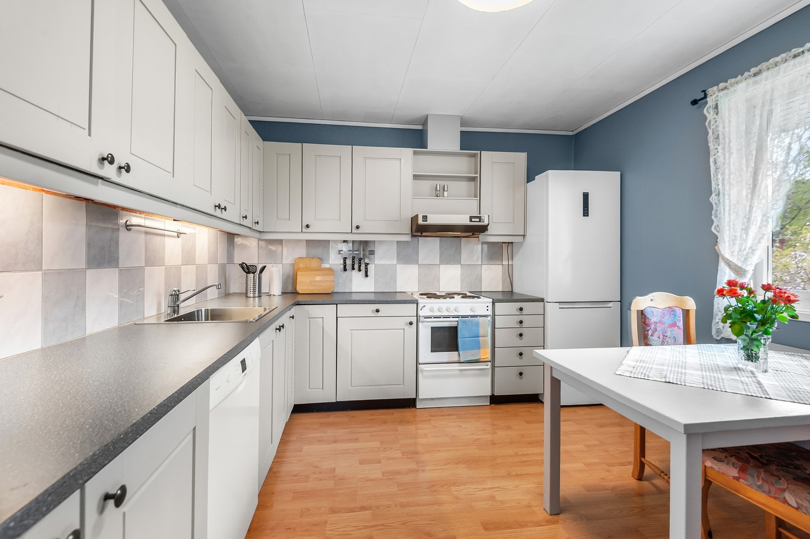 Kjøkken med mye skap -og benkeplass. Galleribilde