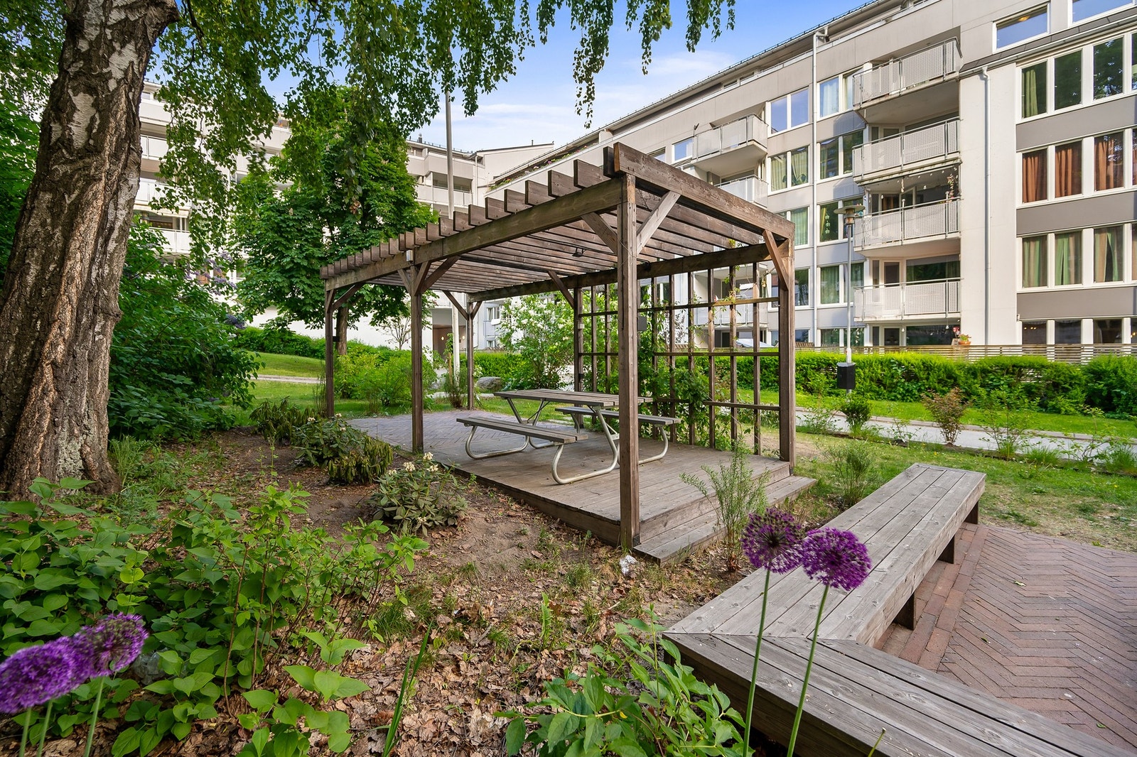 Sittebenker ved fin pergola i sameiets bakgård som beboerne kan benytte seg av. Galleribilde