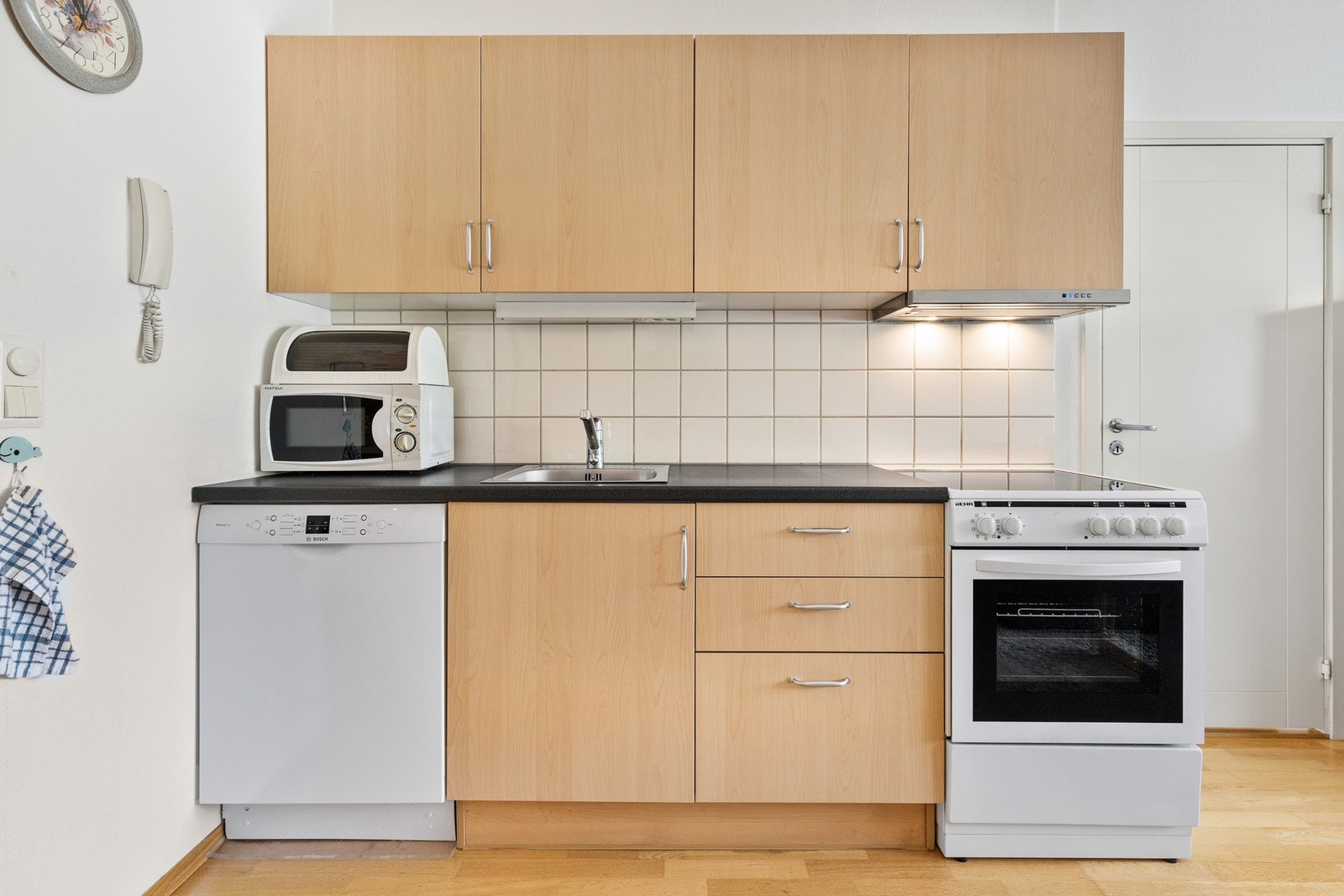 Kjøkkeninnredning med slette fronter, laminert benkeplate og frittstående hvitevarer Galleribilde