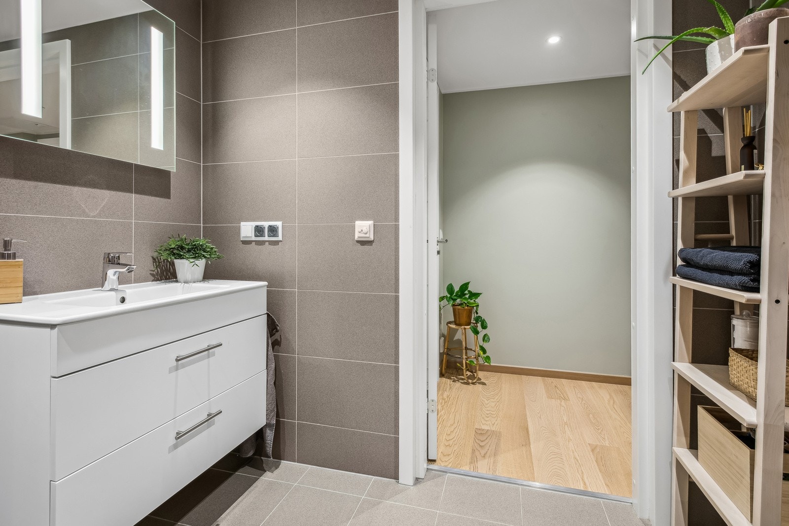 Dette baderommet er utstyrt med vegghengt servant og hjørnedusj med innfellbare dører. Galleribilde