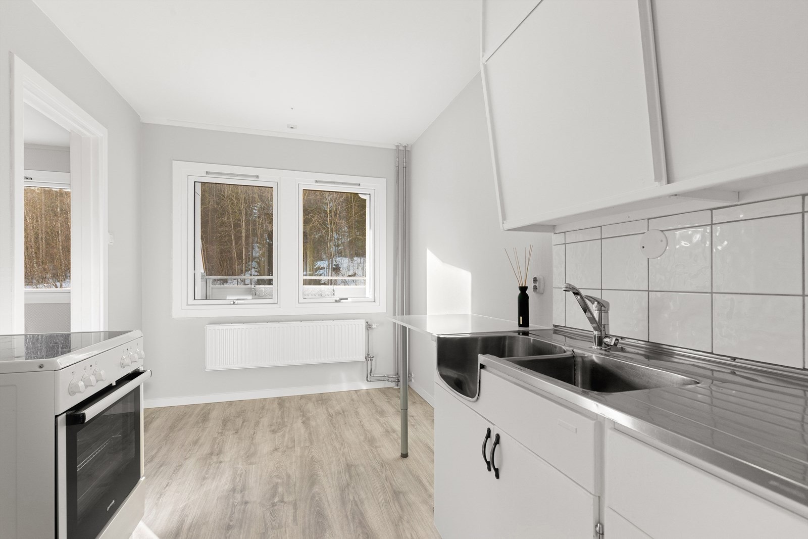 Kjøkkenet har skyveskap øverst og skap nede. De store vinduene gir godt med naturlig lys inn Galleribilde