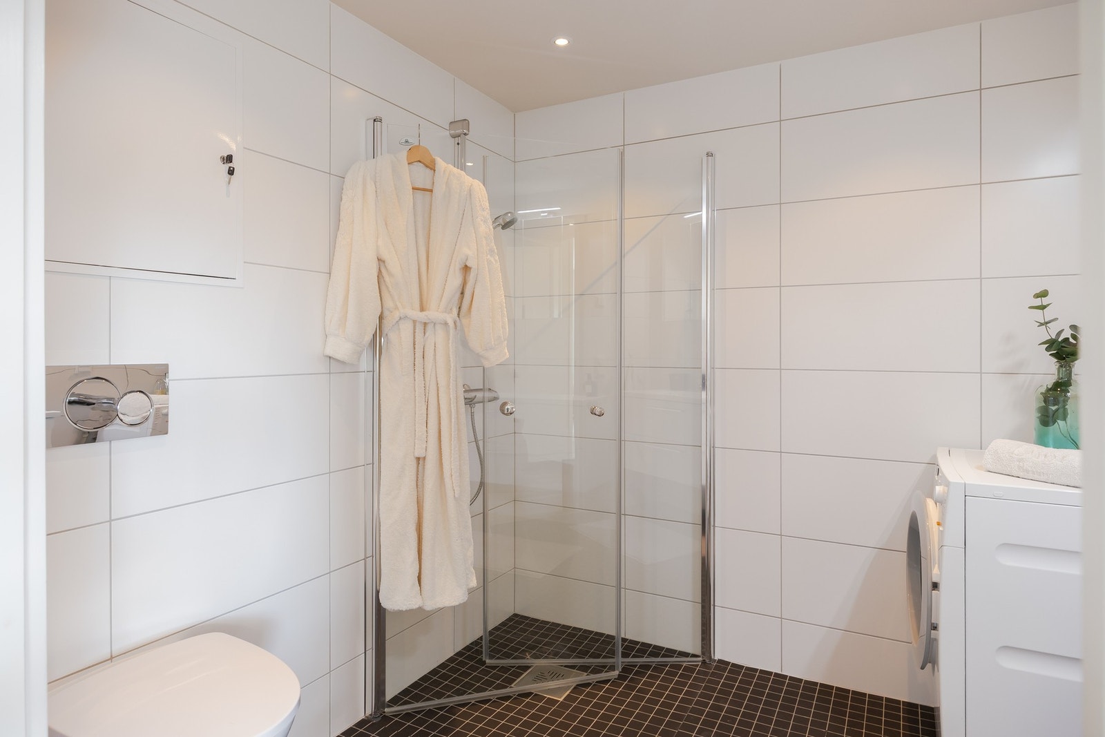 Her er baderomsinnredning fra HTH, dusjhjørne med innfellbare glassdører, vegghengt toalett og opplegg for vaskemaskin. Galleribilde