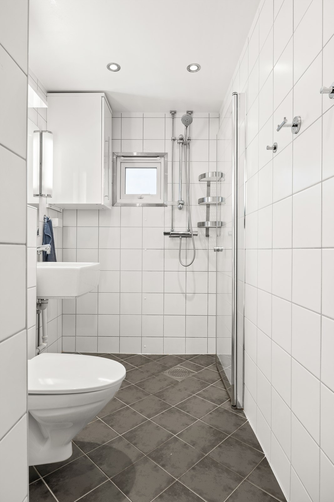 Badet har praktisk dusjhjørne, servant, toalett, opplegg for vaskemaskin og varmekabler i gulv Galleribilde