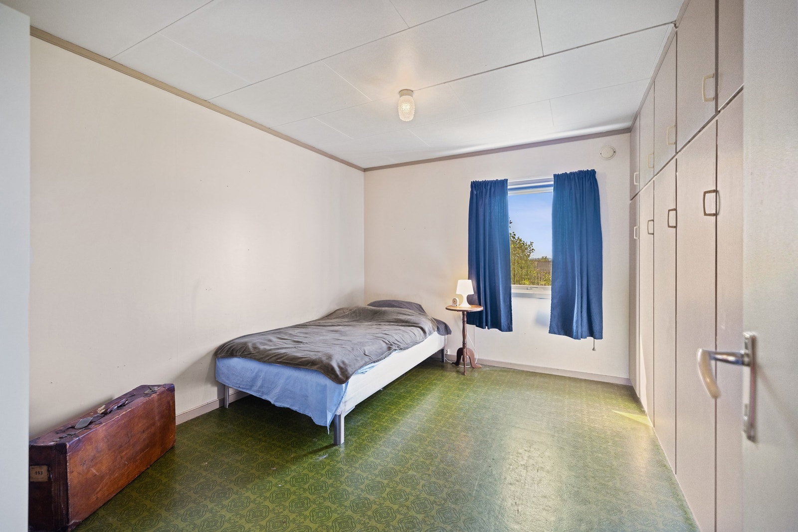 Boligen har to godkjente soverom. Ett soverom har grønt belegg på gulvet og lysmalte vegger. Rommet er innredet med plassbygd garderobeskap på en hel vegg, og stort vindu i endeveggen. Galleribilde