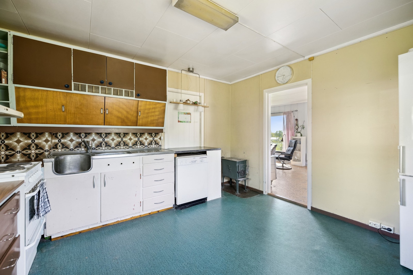 Åpen løsning for frittstående hvitevarer som komfyr, oppvaskmaskin og kjøl-/fryseskap på kjøkkenet. Kjøkkenventilator med avtrekk ut gjennom yttervegg montert over komfyrplassen. Galleribilde