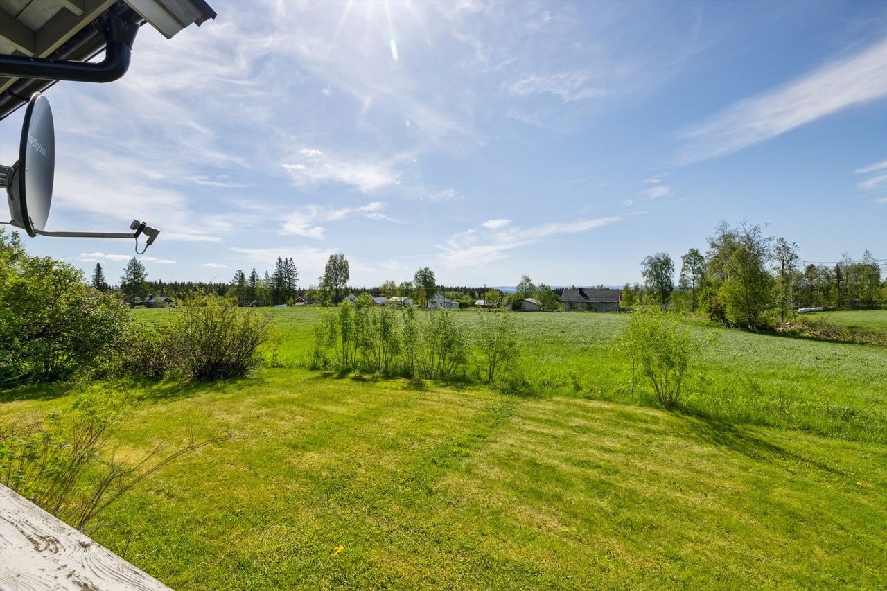 Utsikt fra terrassen utover hagen og jordet. Galleribilde