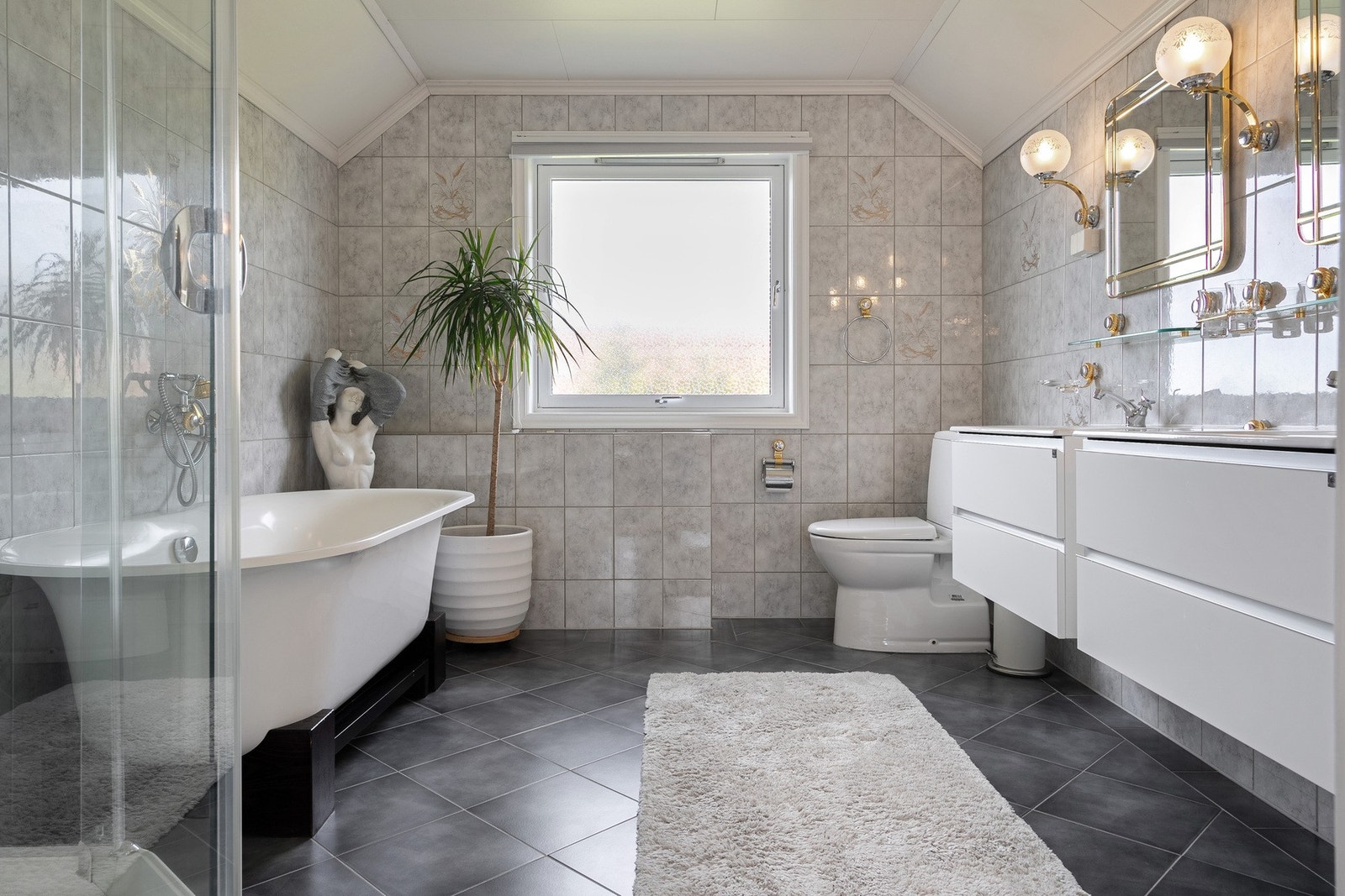 Lyst og romslig bad i andre etasje med servantinnredning, speil med belysning, badekar, dusjkabinett og toalett. Galleribilde