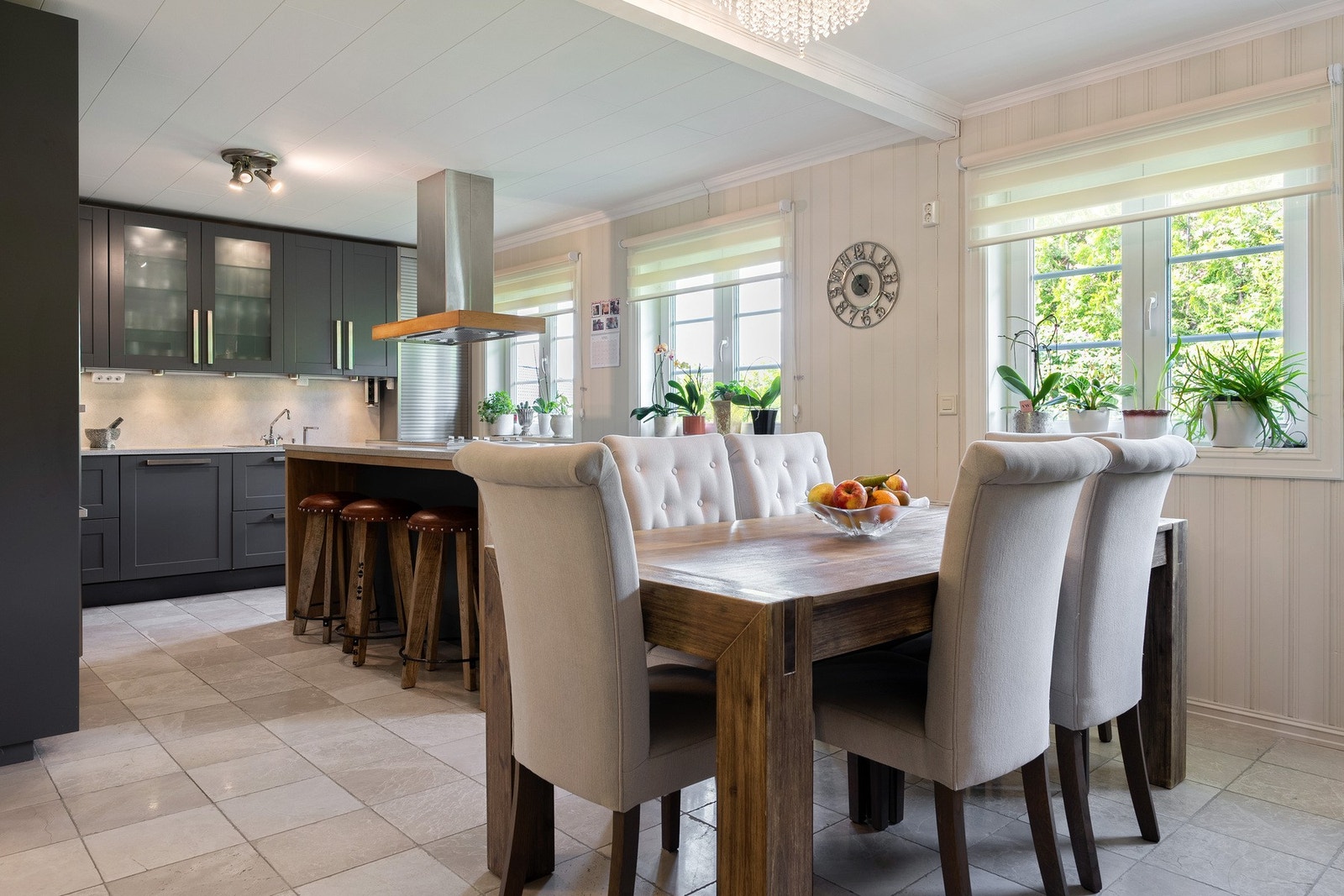 Elegant og velutstyrt kjøkkeninnredning fra Huseby med profilerte fronter og benkeplater i stein. Galleribilde