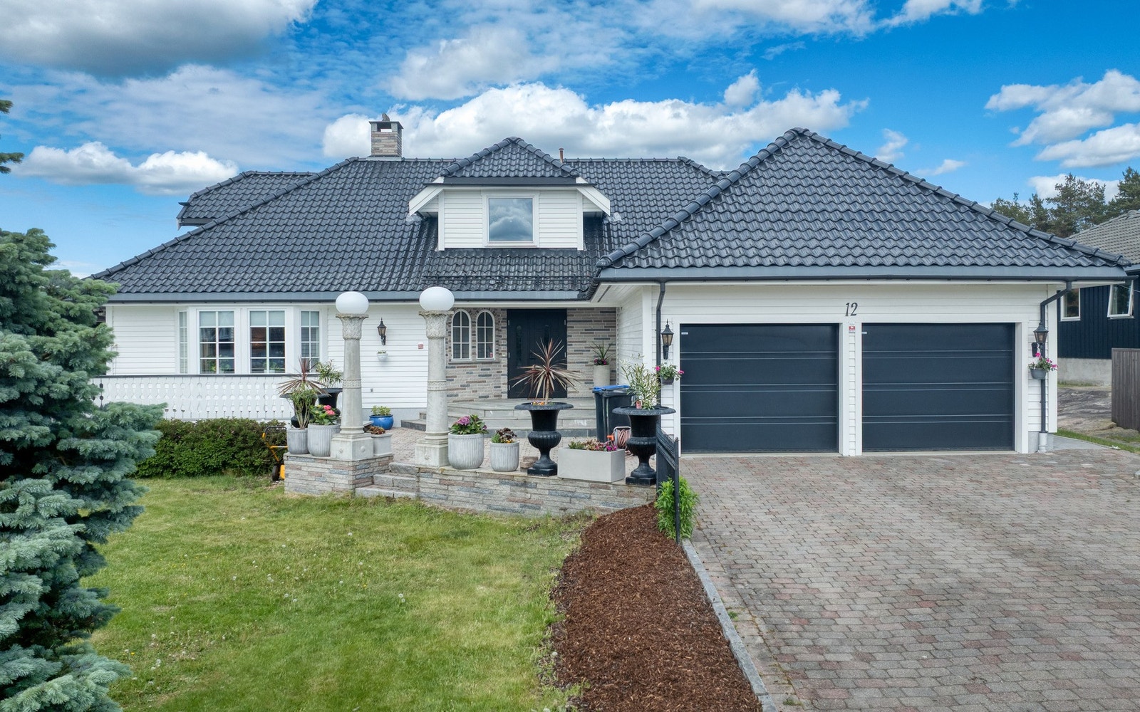 Tomten er pent opparbeidet solrike uteplasser, gressplen, beplantning og steinlagt innkjørsel med biloppstillingsplasser Galleribilde