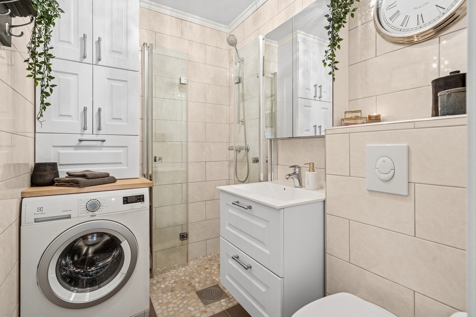 Badet er pusset opp i 2013 og fremstår moderne og innbydende, med lyse beige fliser på veggene og et stilrent uttrykk. Galleribilde