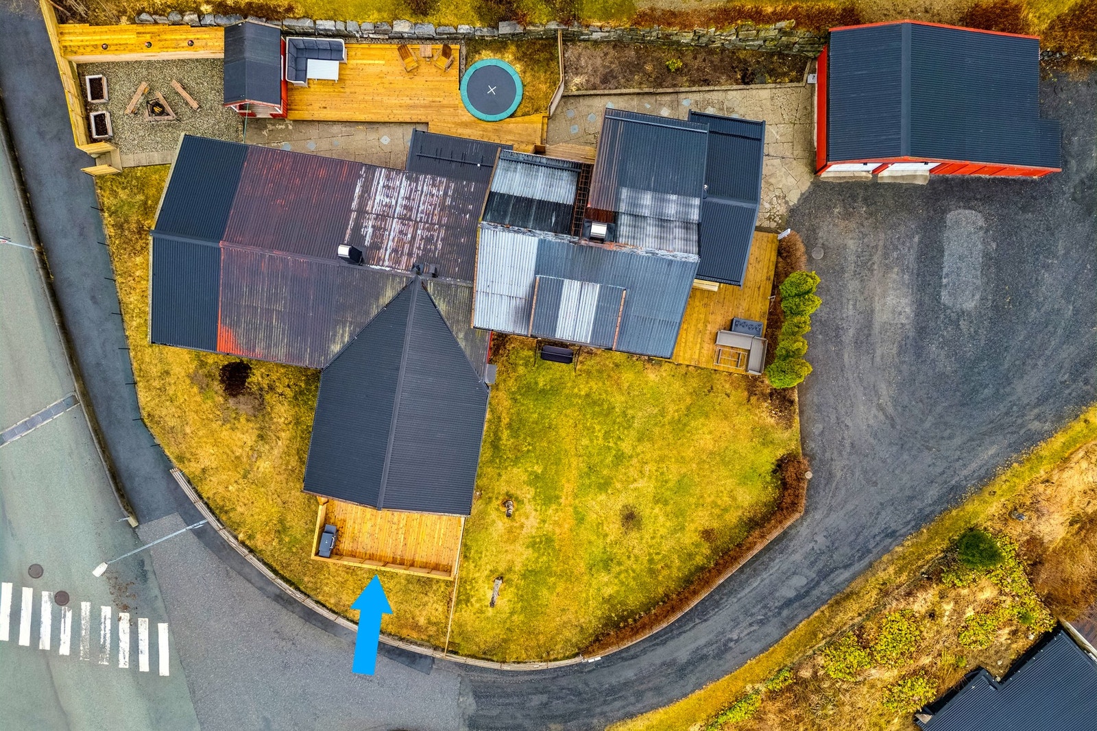 Oversikt av uteområdet. Her er det plass til sykler, lek og hverdagsliv. Parkering på gruset innkjørsel ved siden av garasjen. Galleribilde