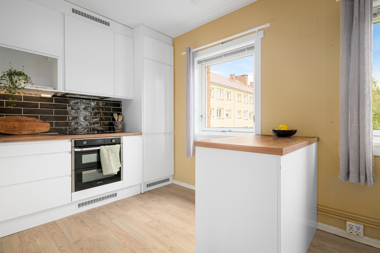 Stilrent og funksjonelt Epoq-kjøkken fra 2020 med integrerte hvitevarer og god arbeidsflate. Persienner og naturlig lys. Galleribilde