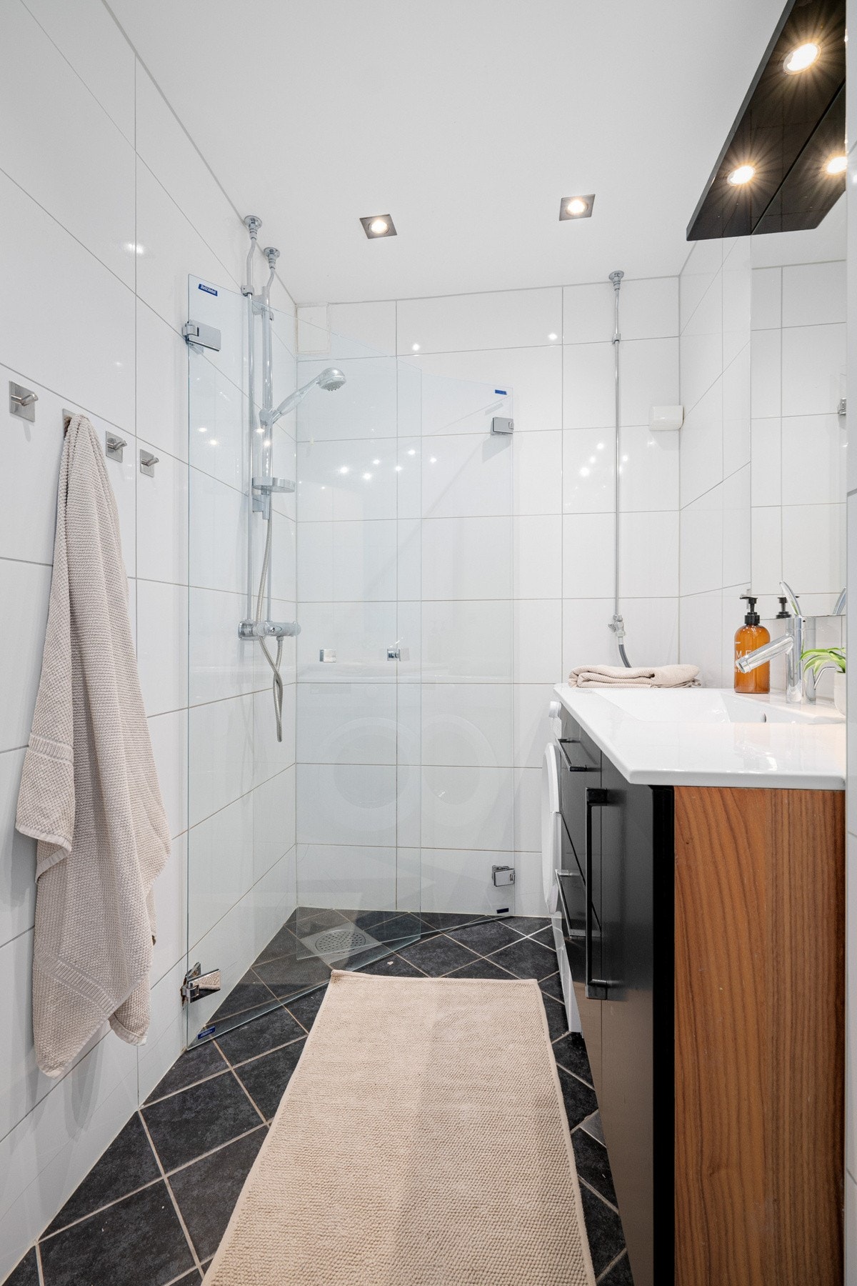 Dusj med innfellbare glassdører og opplegg for vaskemaskin. Galleribilde