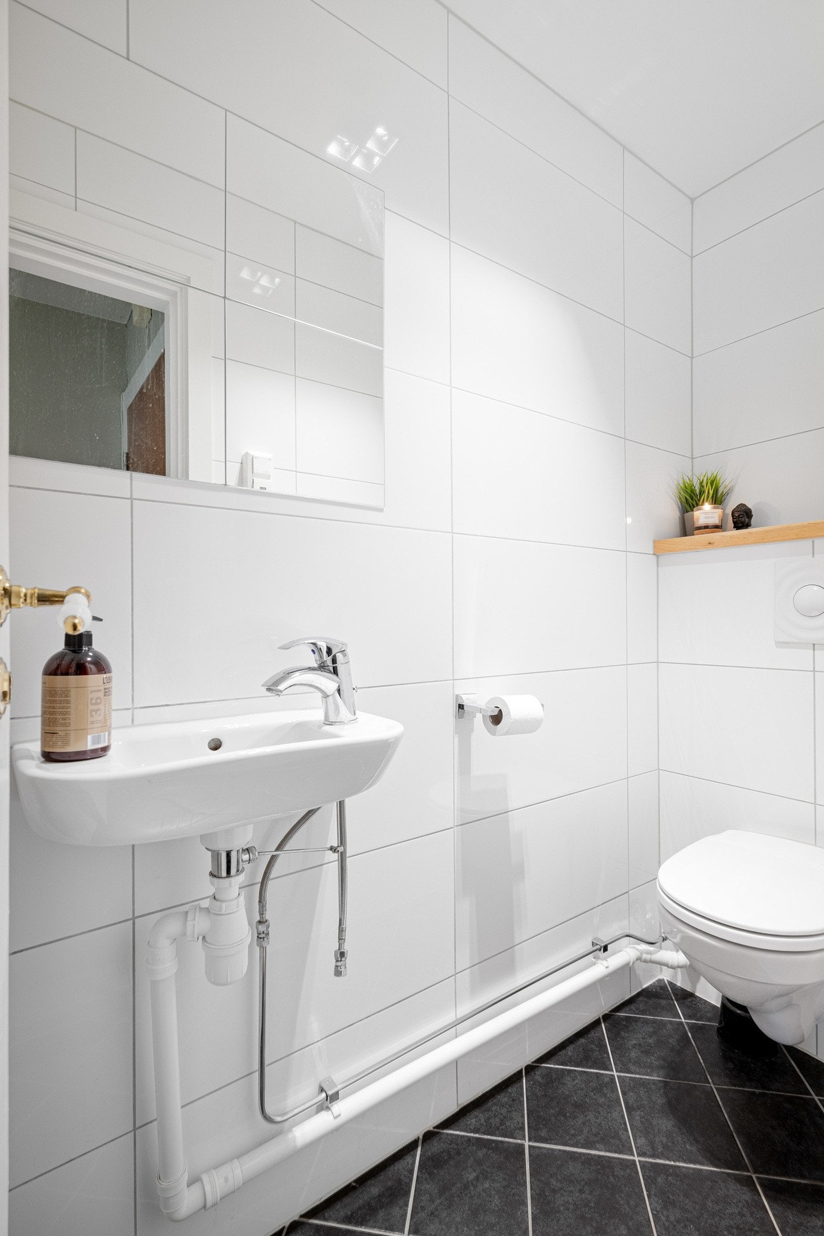 Separat flislagt toalettrom med servant og speil. Galleribilde