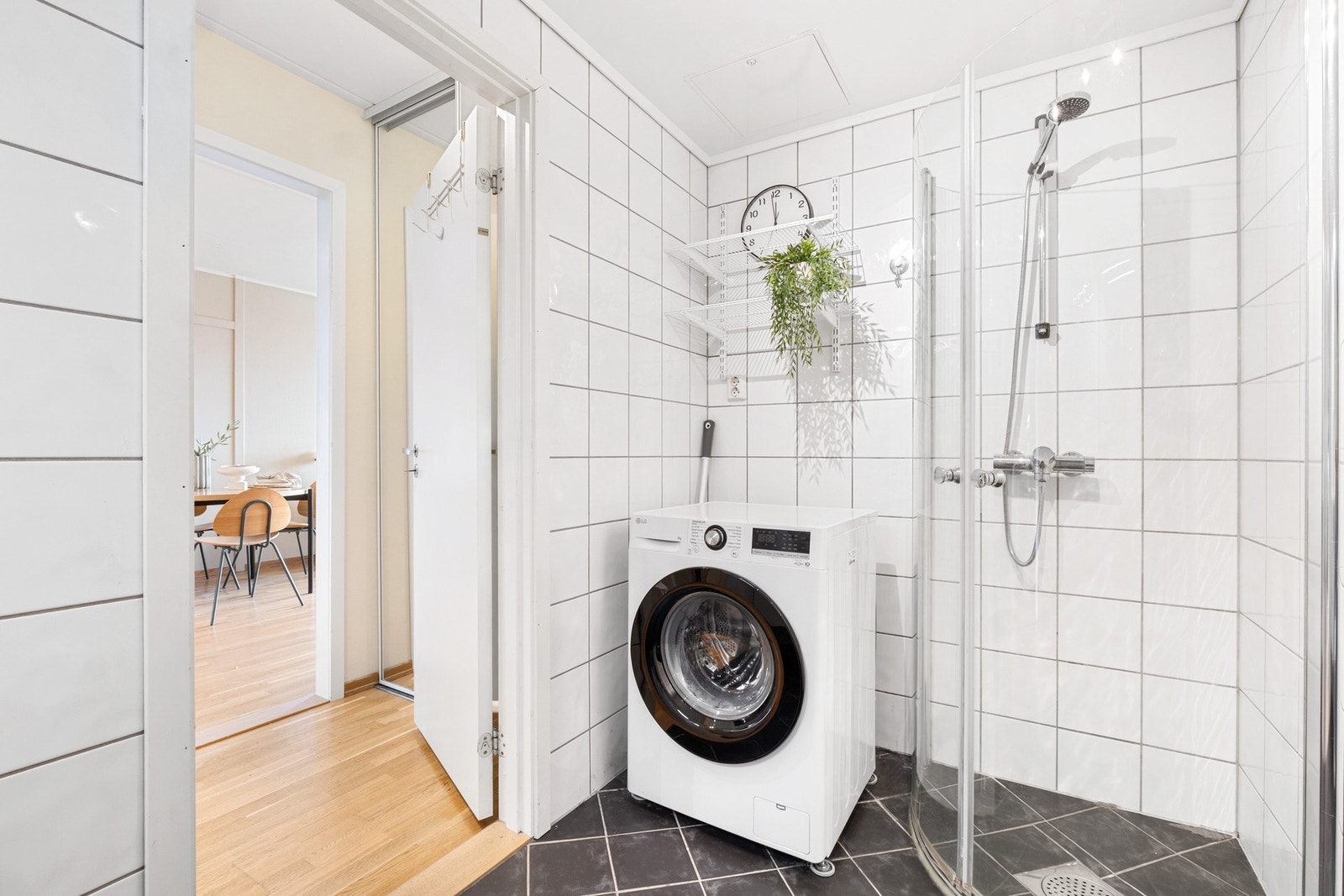 Det flislagte badet har en tidløs og stilren utstråling med hvite fliser på vegg og mørke fliser på gulvet. Galleribilde