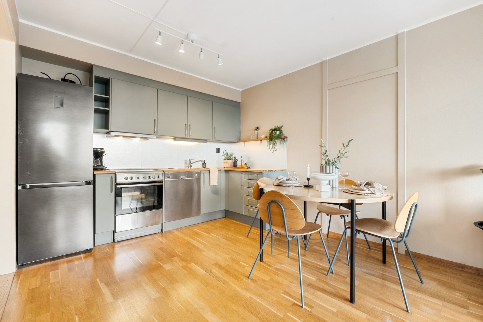 Kjøkkenet er rikelig utbygd med over- og underskap. Innredningen har en lekker grønnfarge med fin kontrast til benkeplate og svare detaljer. Galleribilde