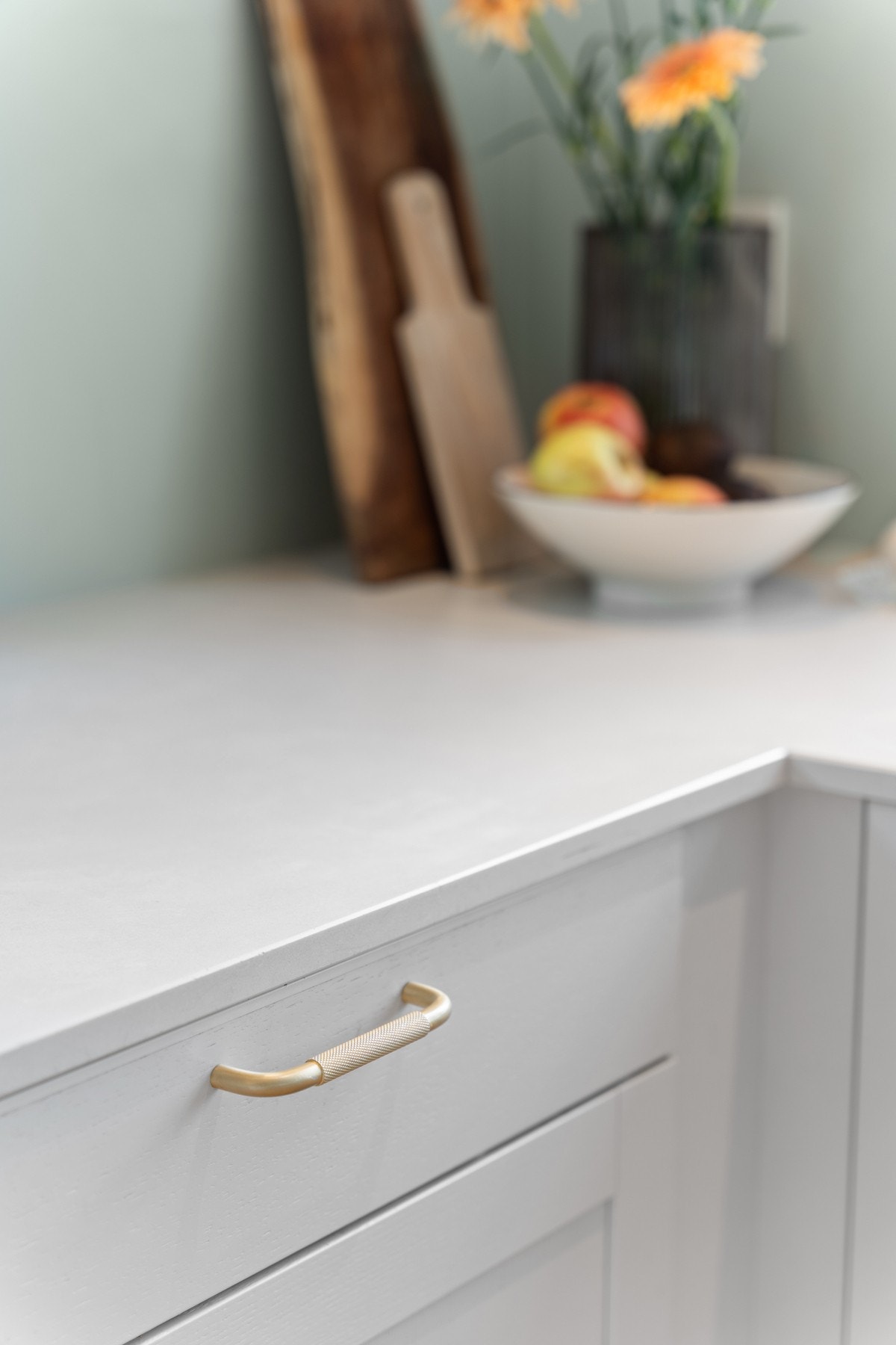 Benkeplate i hvit kvartsittkompositt fra kvalitetsmerket Caesarstone®. Alle håndtak av messing. Galleribilde