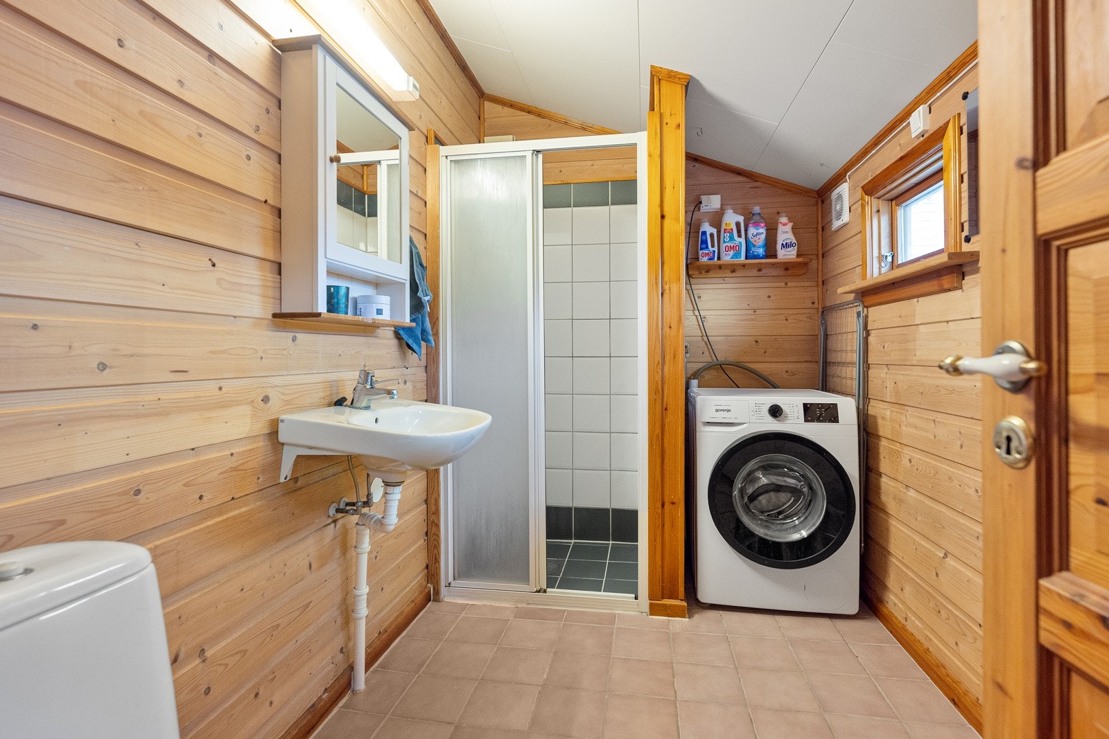 Badet i annekset er innredet med toalett, servant, dusjnisje og opplegg for vaskemaskin. Galleribilde