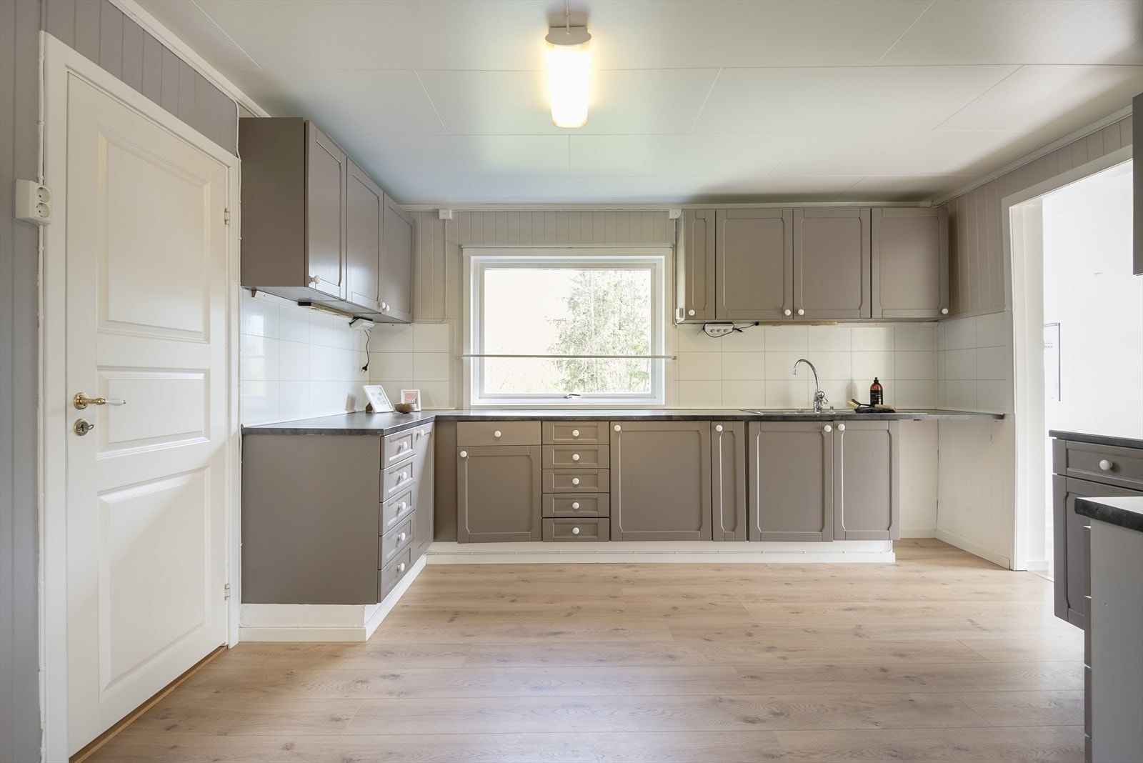 Romslig kjøkken med malt innredning. Galleribilde