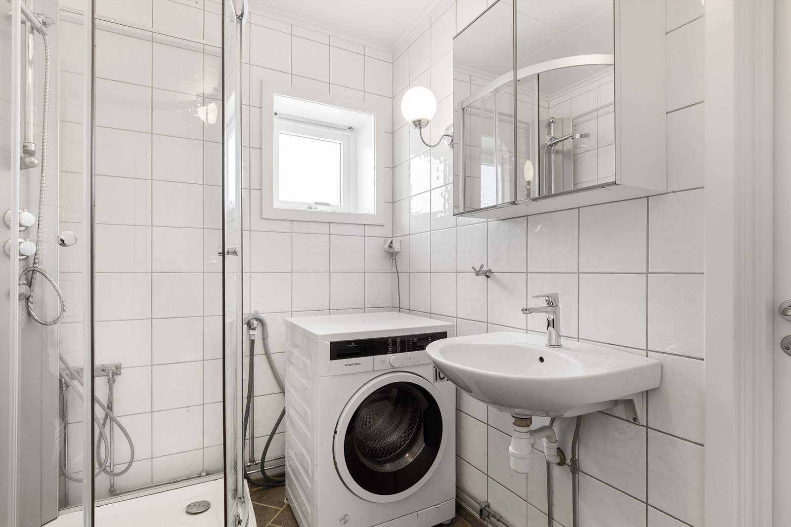 Badet har servant, vegghengt toalett, opplegg for vaskemaskin og tett dusjkabinett - varmekabler i gulv. Galleribilde