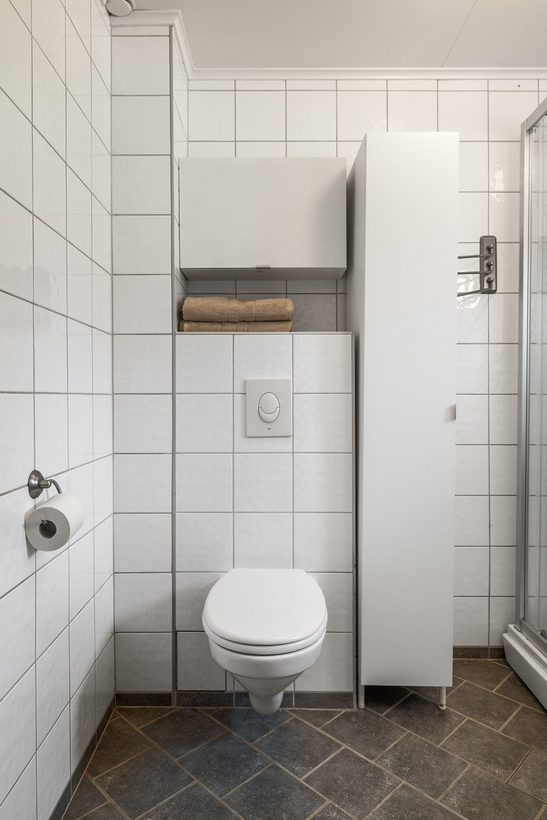 Bad/vaskerom i første etasje har fliser på gulv og vegger og malte himlingsplater. Galleribilde