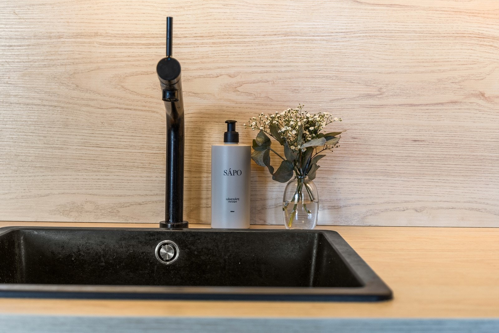 Kjøkkenet har integrerte hvitevarer som oppvaskmaskin, induksjonstopp, mikrobølgeovn, og frittstående kjøl/fryseskap Galleribilde