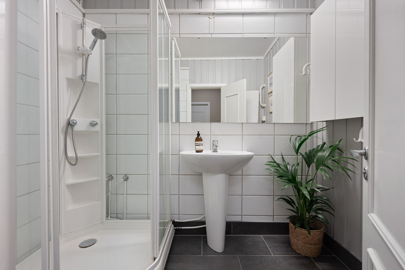Badet i 2. etasje er innredet med dusjkabinett og baderomsinnredning med servant og vegghengt skap. Det er også varmekabler. Galleribilde