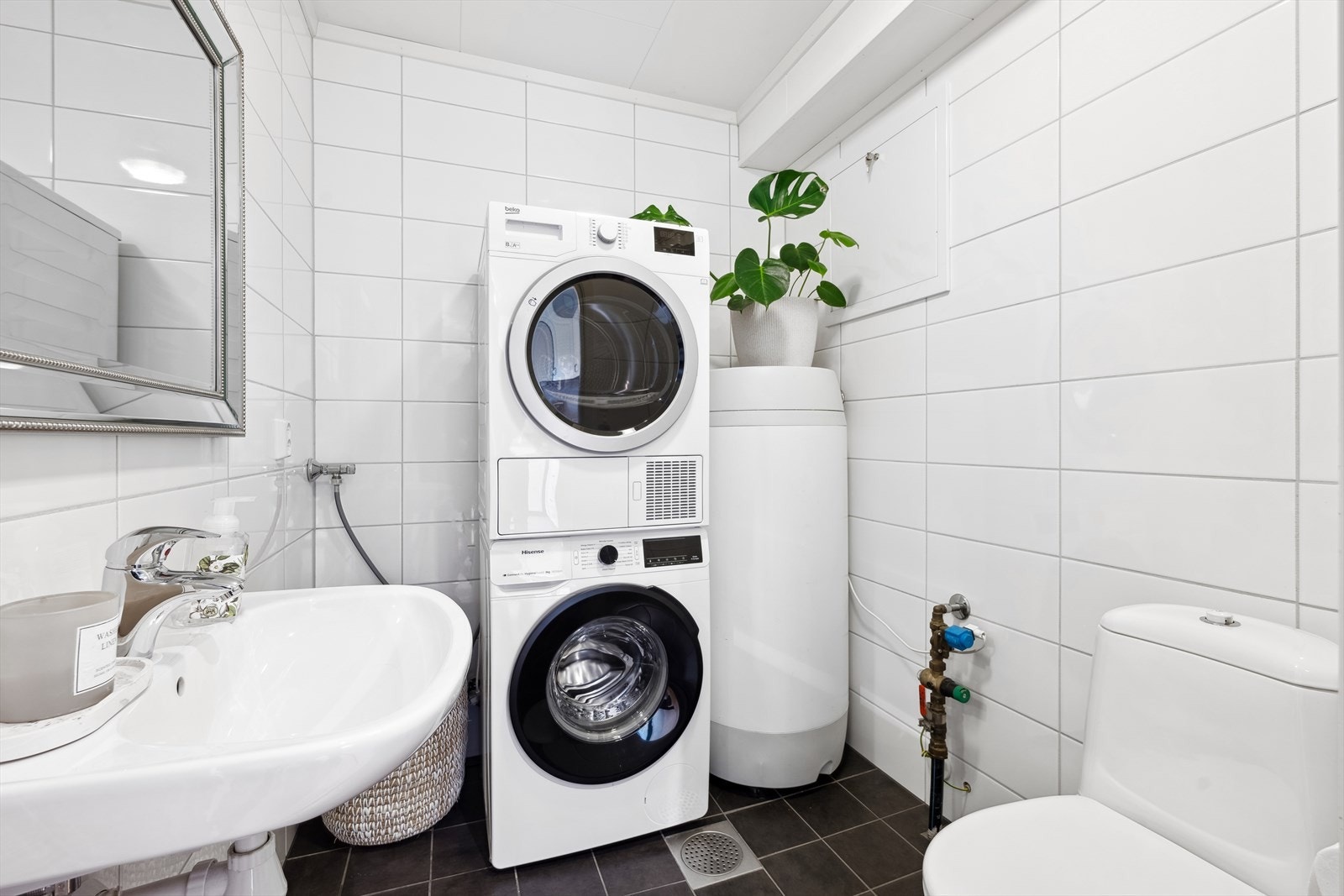Pent flislagt vaskerom med wc, vask og opplegg for vaskemaskin. Varmekabler i gulv. Galleribilde
