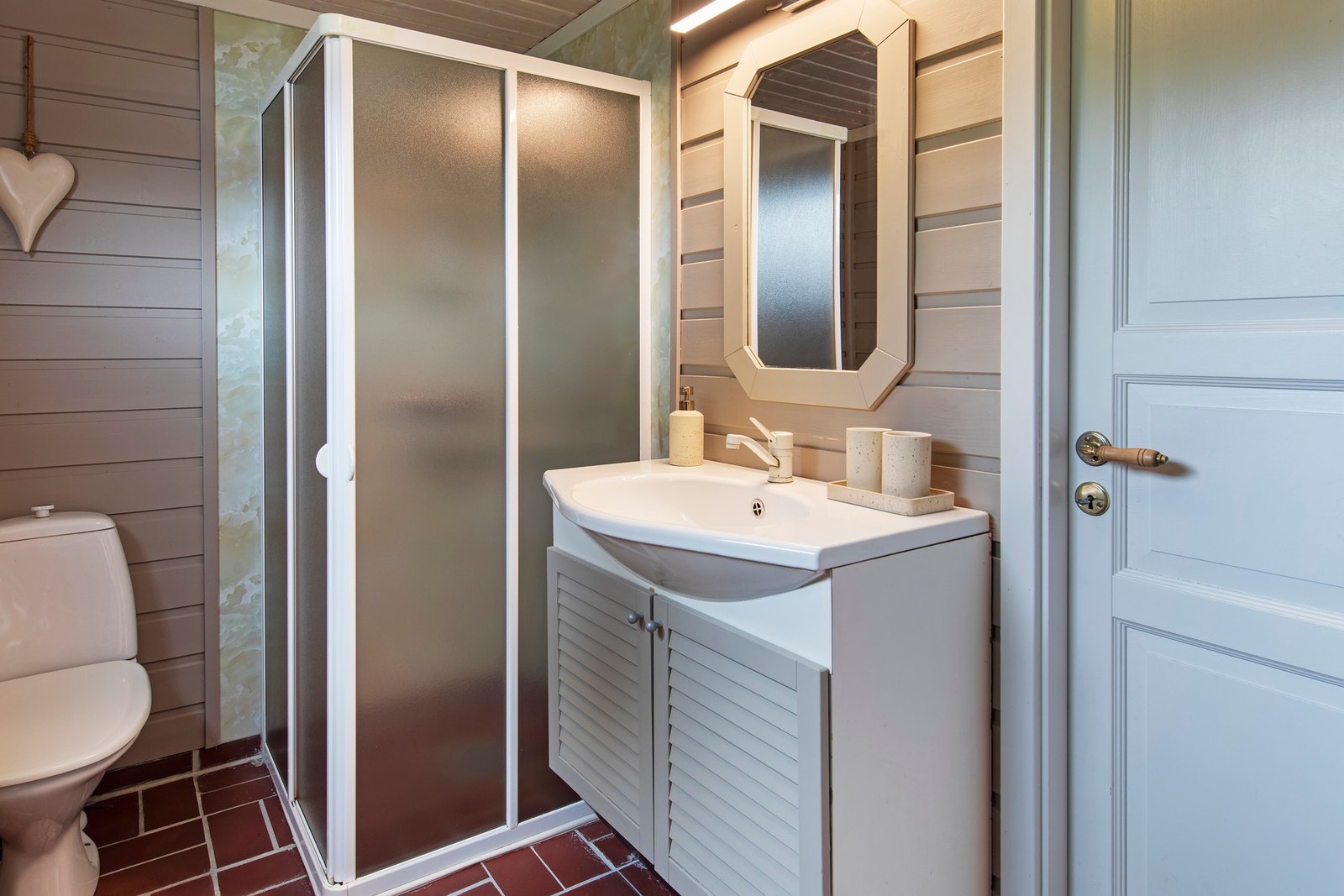 Malt innredning med heldekkende servant. Gulvstående toalett og dusjhjørne Galleribilde