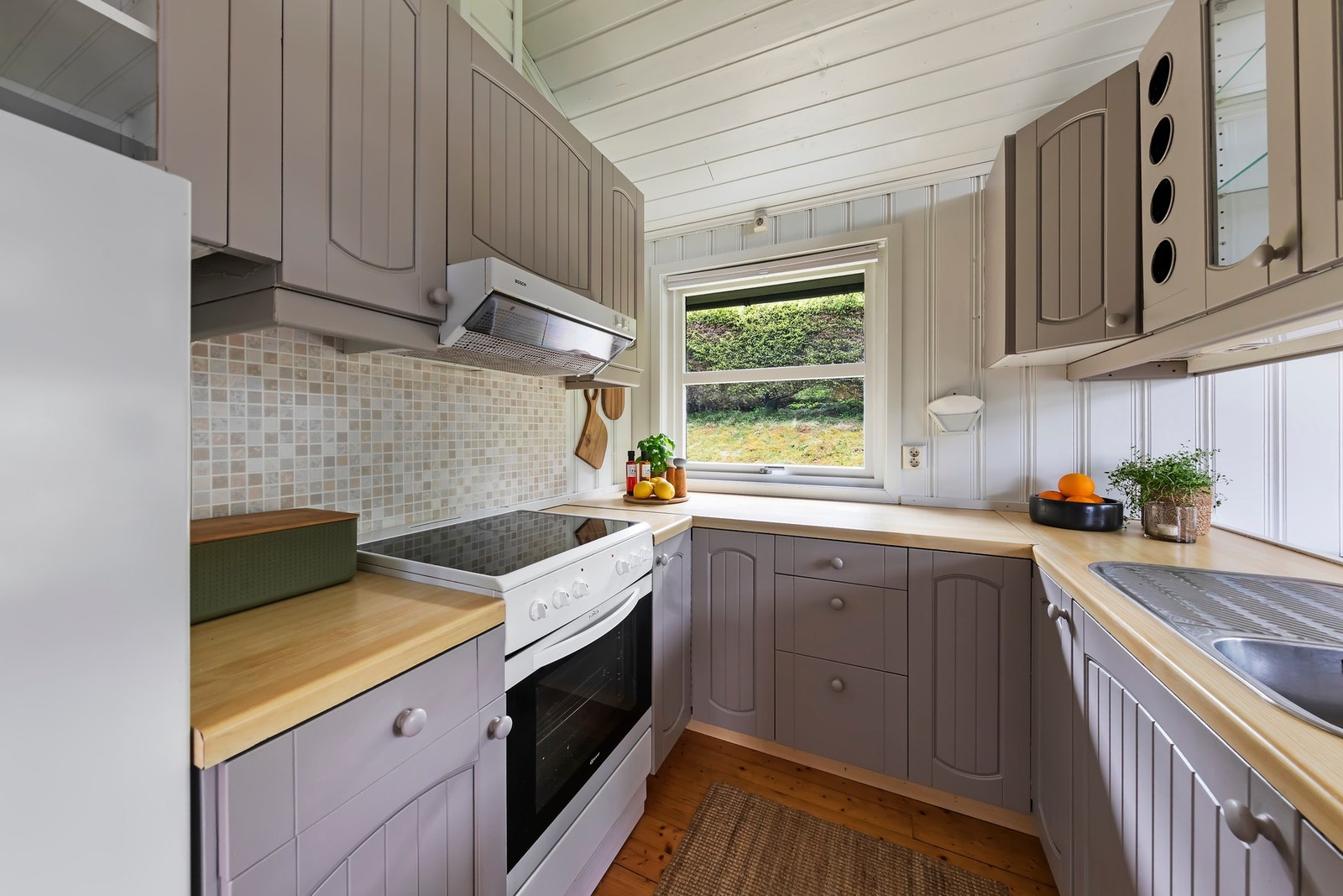 Kjøkkeninnredningen har malte profilerte fronter og benkeplate i laminat Galleribilde