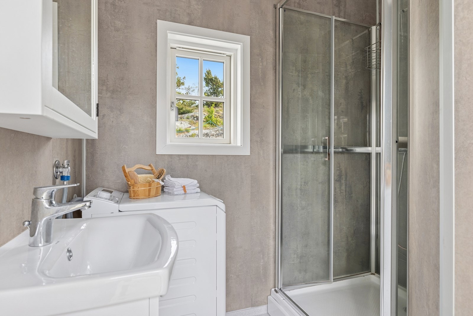 Bad/vaskerom fra 2019. Rommet er innredetmed servantskap og dusjkabinett. Det er opplegg for vaskemaskin. Galleribilde