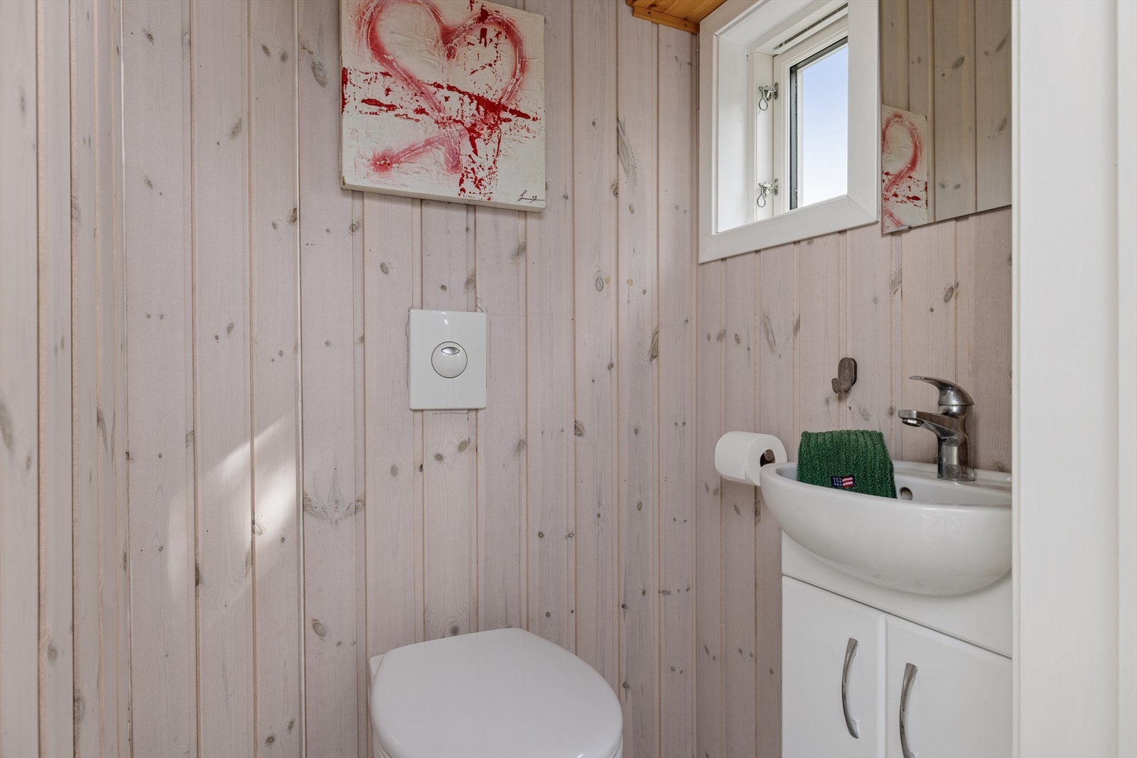 Toalettrom fra 2019. Rommet er innredet med et toalett og servantskap. Galleribilde