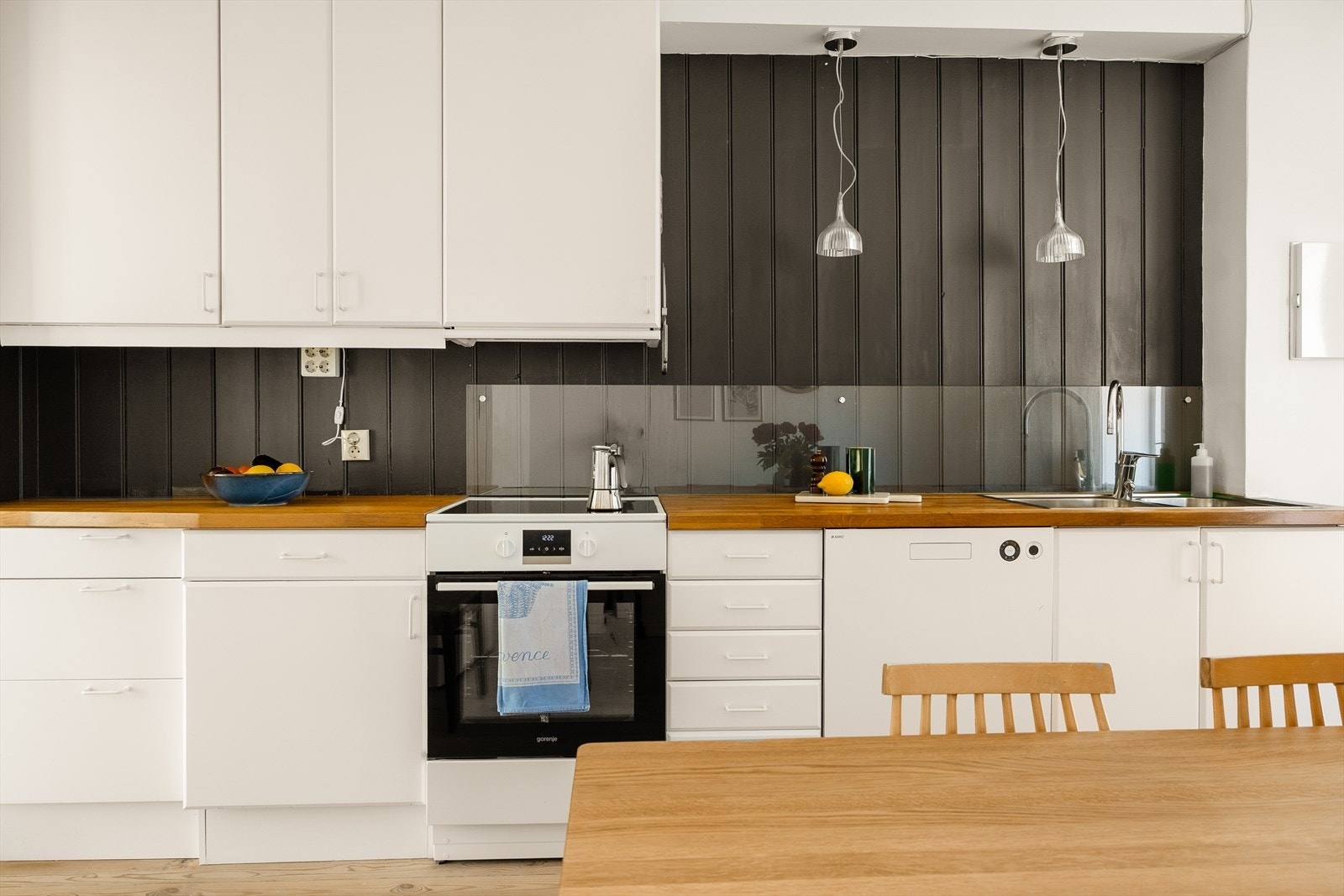 Lyst kjøkken fra IKEA med slette fronter og benkeplater av tre. Galleribilde