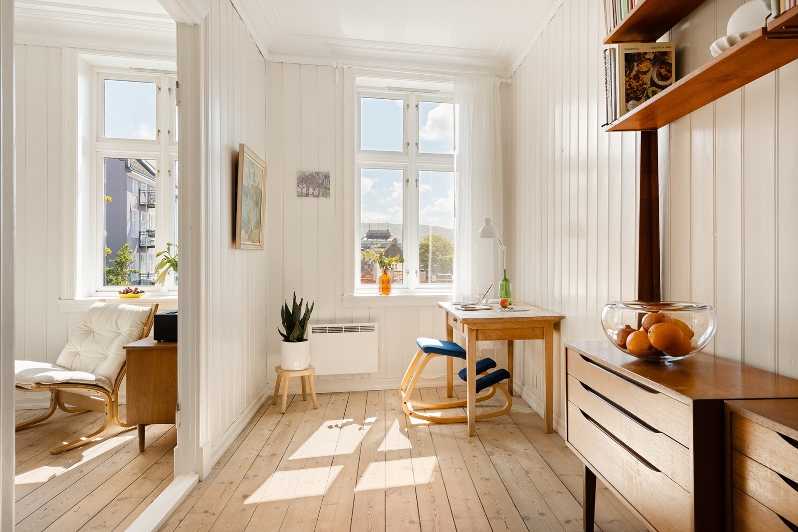 Leilighetens andre stue er perfekt som kontor eller bibliotek. Legg også merke til store vinduer med flott utsikt mot sentrum og byfjellene Galleribilde