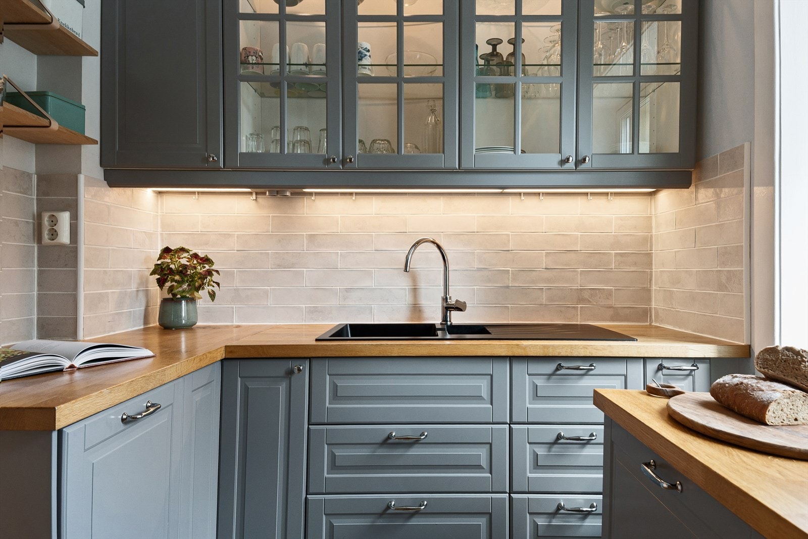 Fliser, belysning og stikkontakt over benken gir en funksjonell arbeidsflate. Galleribilde