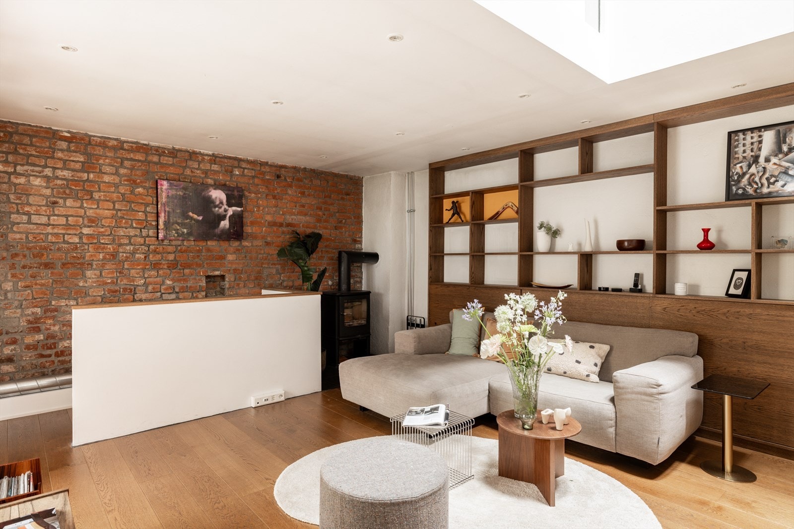 Stuen har en kombinasjonen av nøytrale vegger og eksponert teglsteinsvegg, og har god plass til en stor sofagruppe. Galleribilde