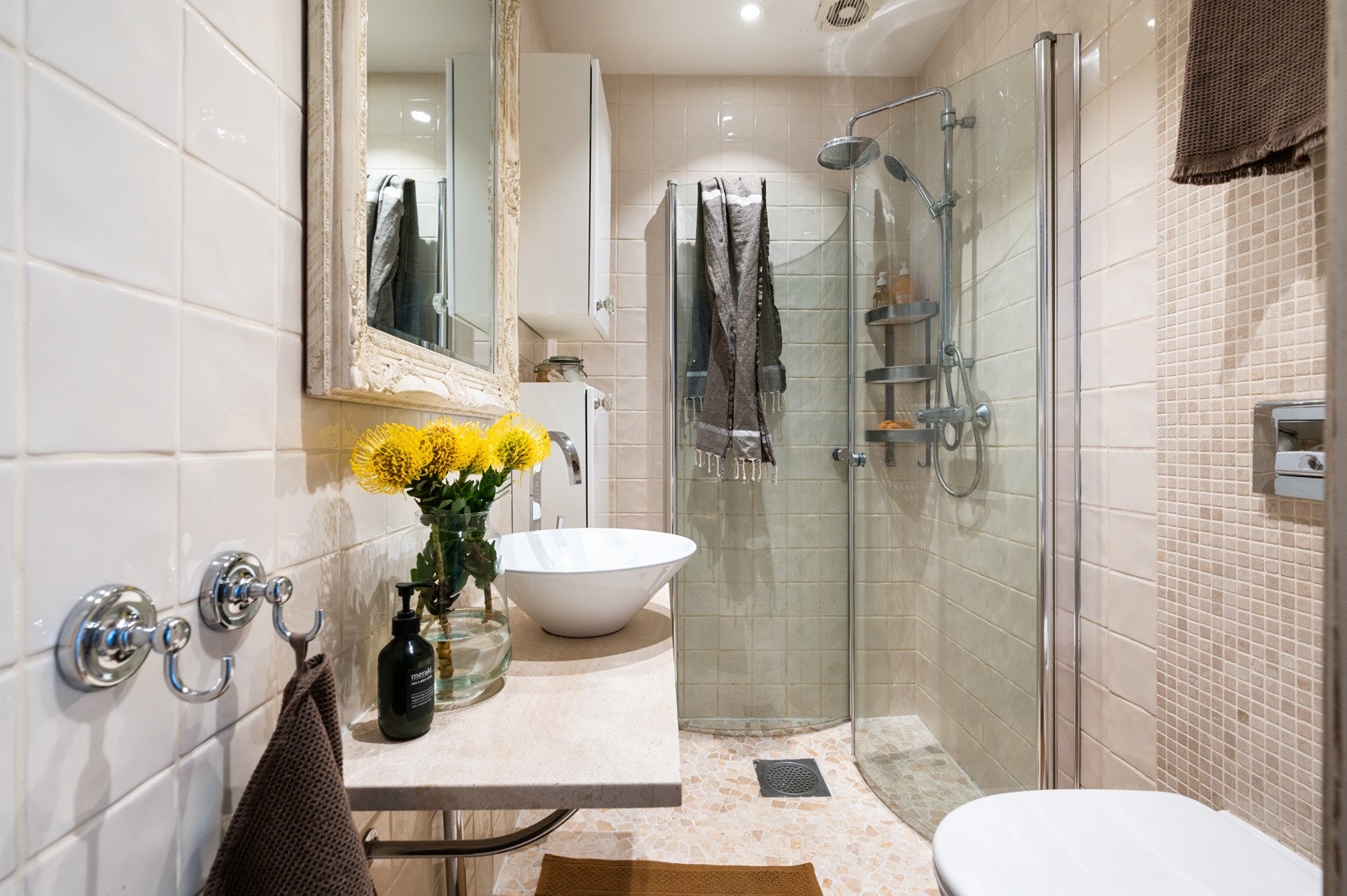 Dusjhjørnet har buede dører i herdet glass og regnfallsdusj, noe som gir en luksuriøs og behagelig dusjopplevelse Galleribilde