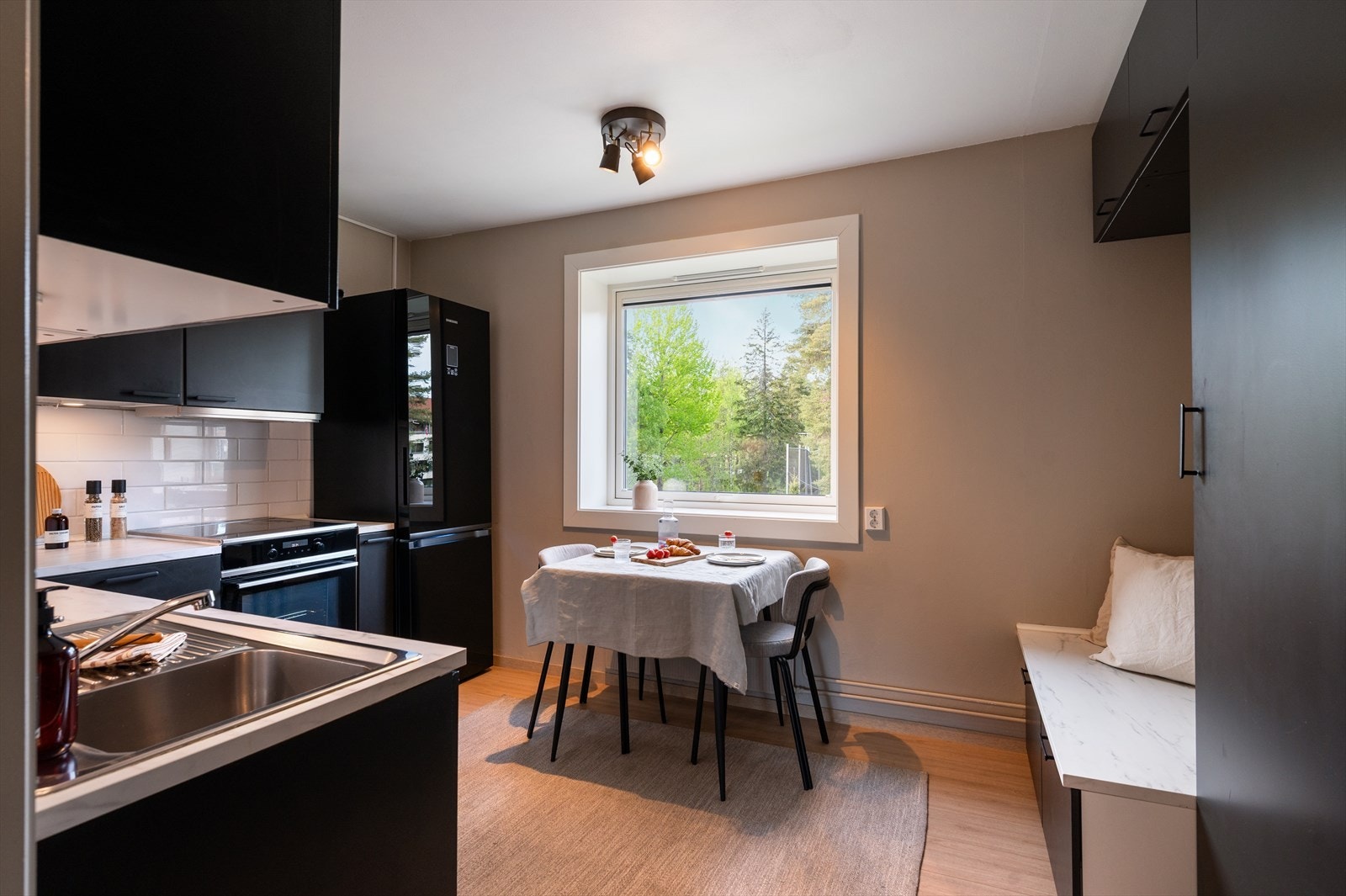 Adskilt kjøkken med plass til frokostbord ved vindu. Galleribilde