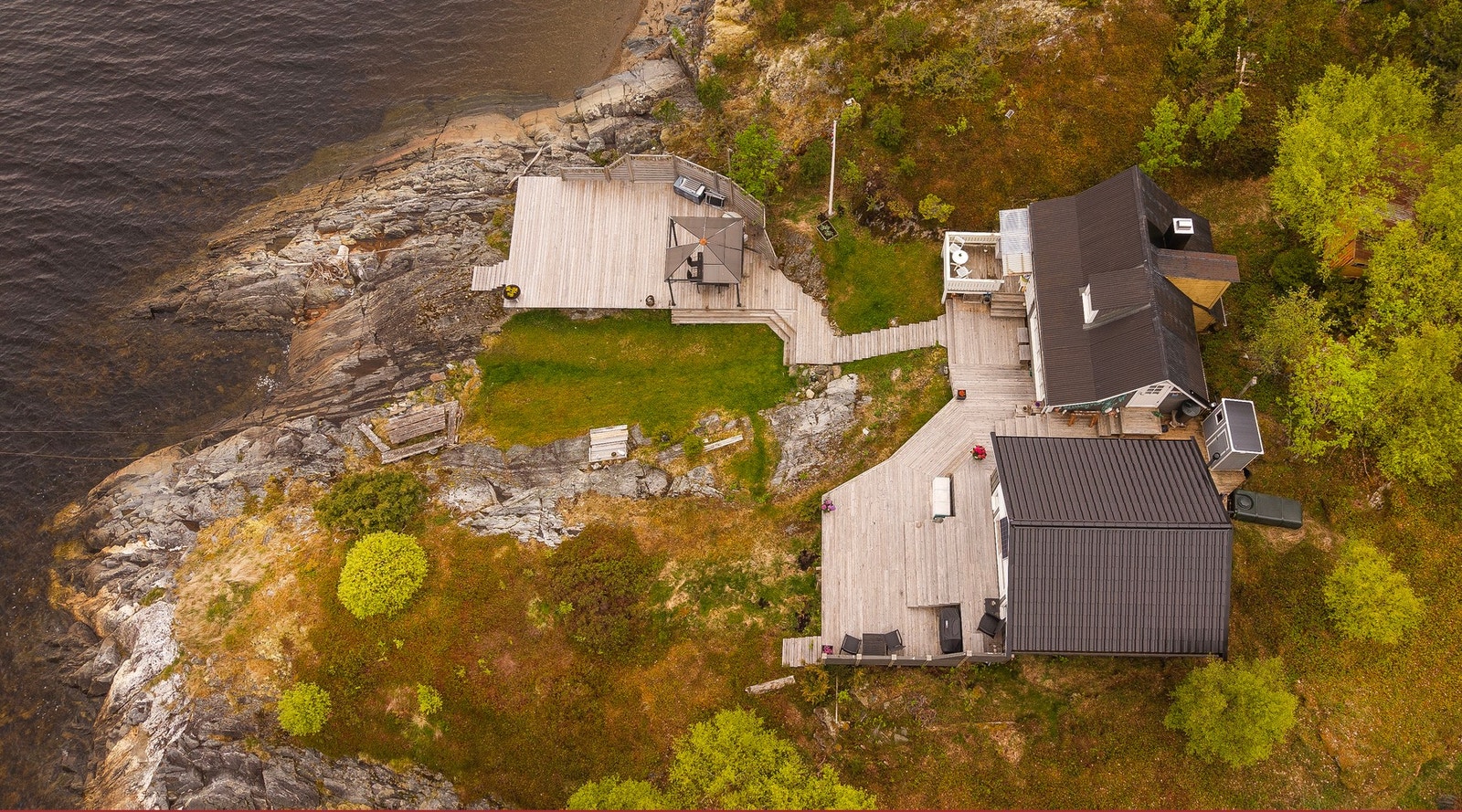 Tomten består hovedsakelig av naturtomt med lyng, lauvtrær og bergnabber Galleribilde