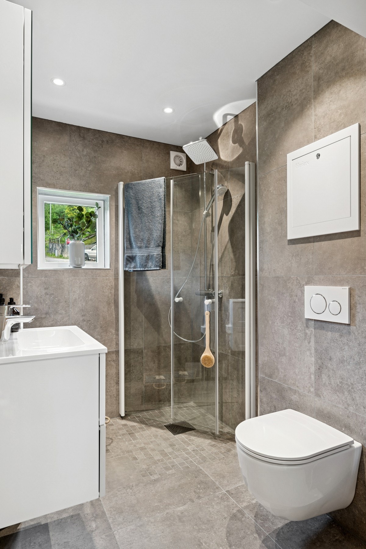 Her får du et delikat flislagt baderom med varmekabler og downlights. Galleribilde