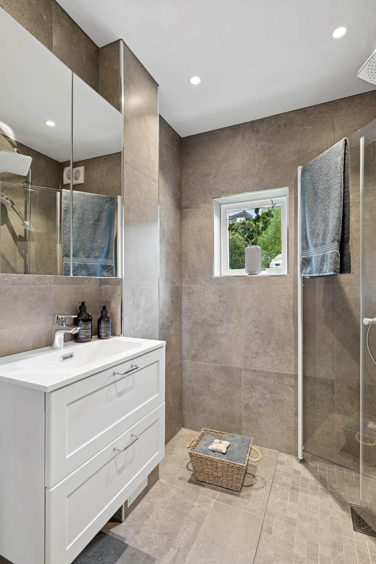 Baderommet er utstyrt med vegghengt toalett, dusjhjørne, servant og speil. Galleribilde