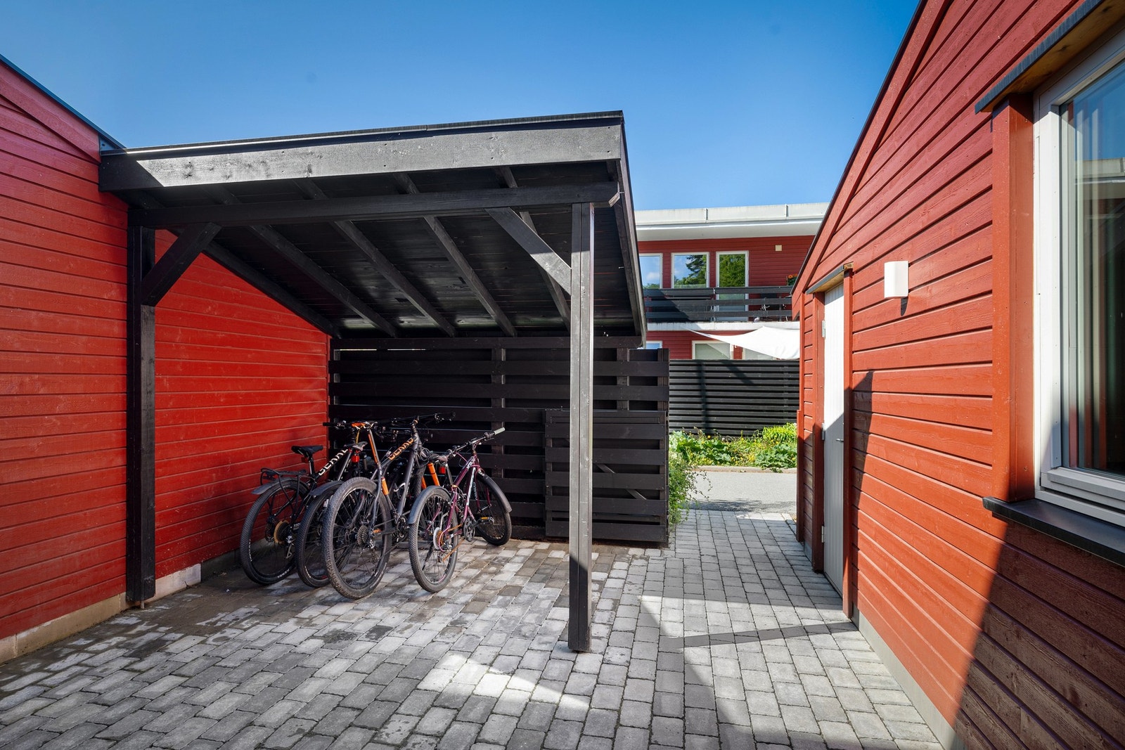 Pent opparbeidet adkomst med belegningsstein, overbygd inngangsparti og tilhørende sportsbod. Galleribilde