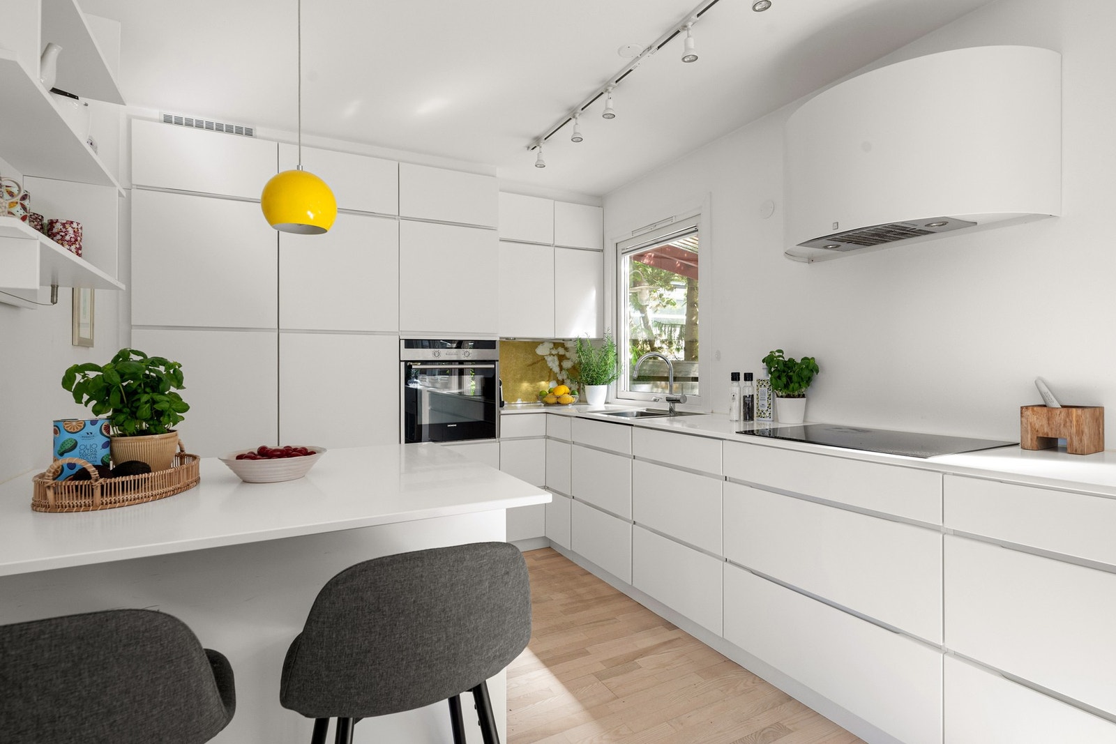 Kjøkkenhalvøy med bardisk gir ekstra arbeidsflate og en naturlig sone for raske måltider eller en kopp kaffe. Galleribilde