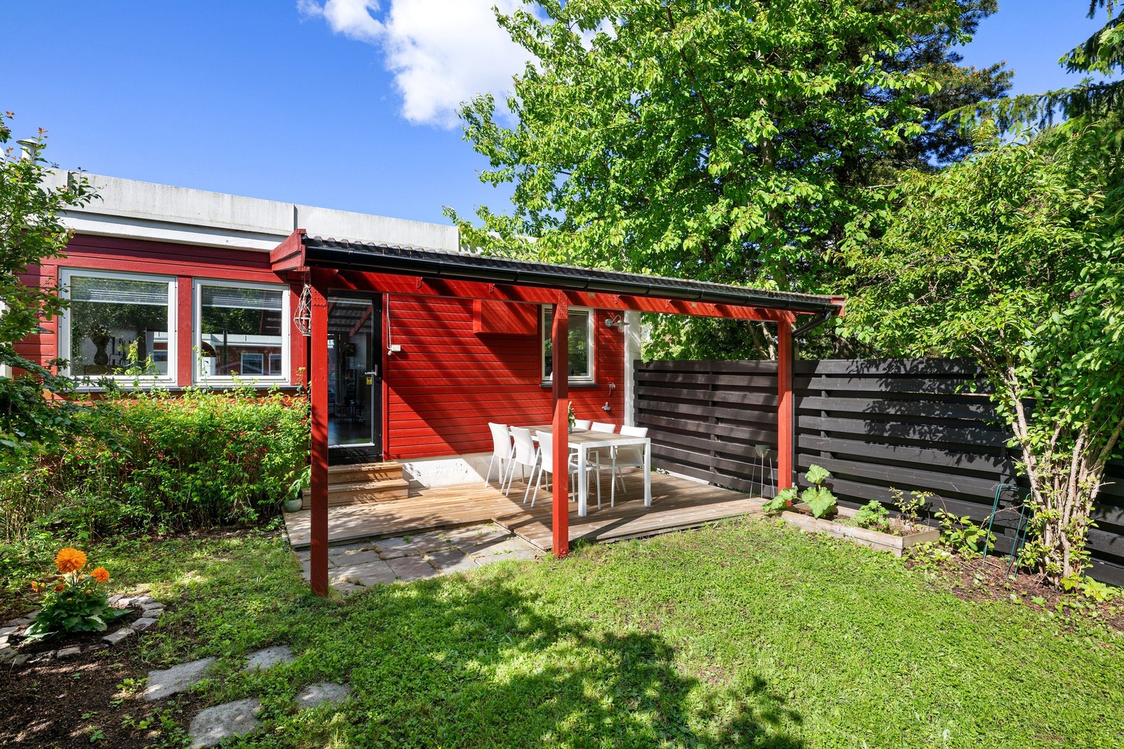 Frodig og innbydende uteområde som kombinerer hagefølelse med praktisk uteplass. Galleribilde