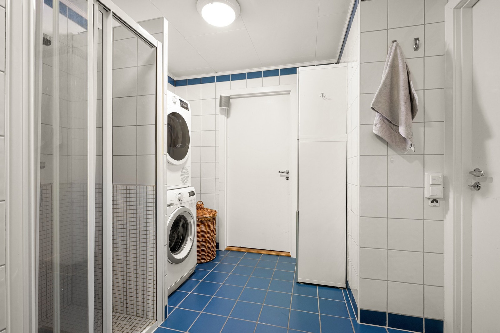 Romslig bad med både dusjsone og badekar. Vaskemaskin og tørketrommel er praktisk plassert i søyle. Galleribilde