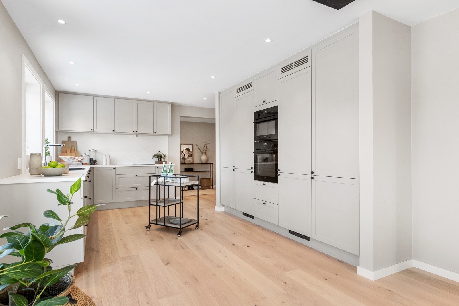 Strai kjøkken med integrerte hvitevarer: stekeovn, kombinasjonsovn med micro, induksjonstopp med ventilator, oppvaskmaskin, hel kjøleskap og hel fryseskap Galleribilde