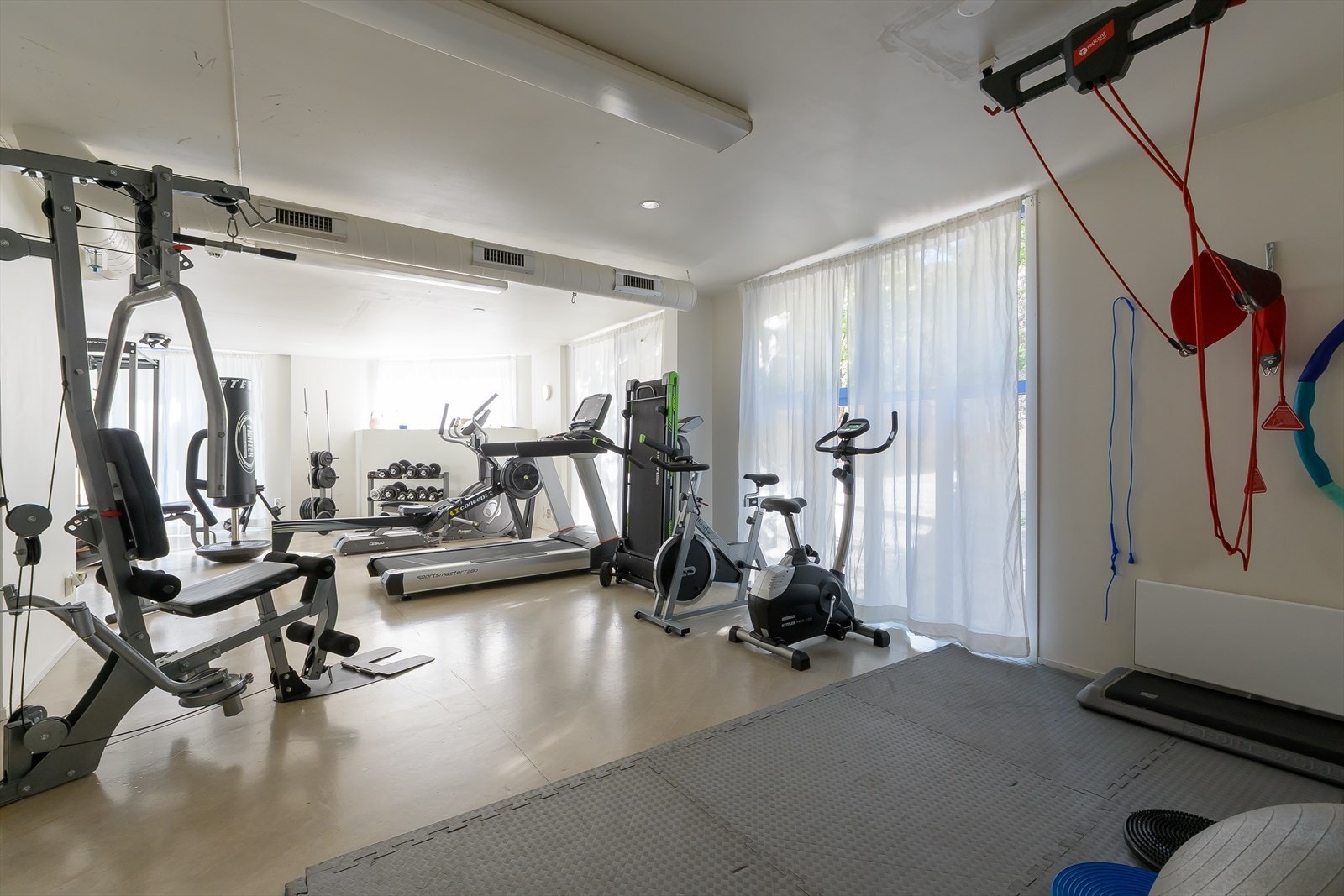 Godt utstyrt treningsrom med boksesekk, strikk, vekter og ulike maskiner Galleribilde